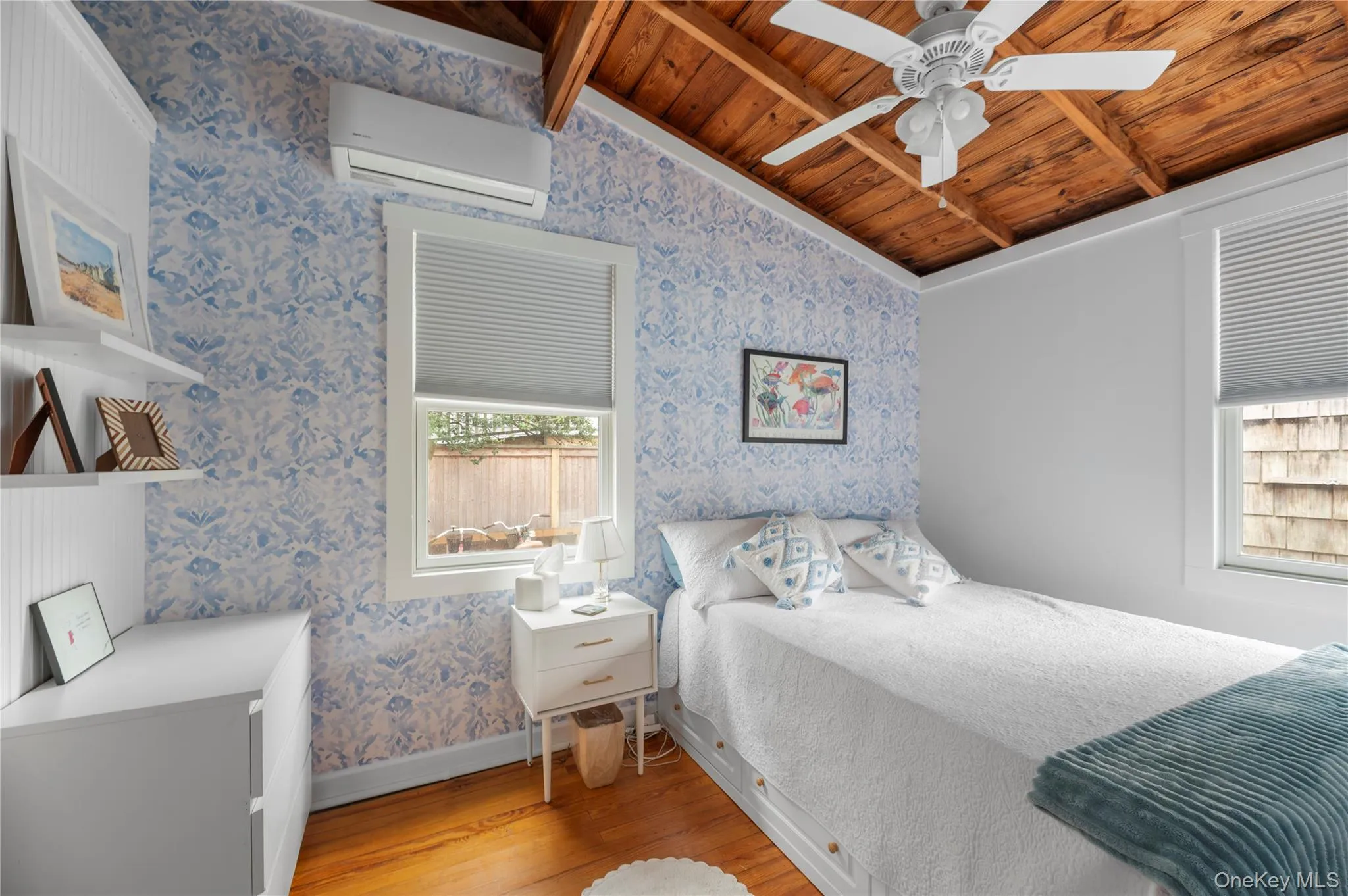 Bedroom with light wood-type flooring, wallpapered walls, wooden ceiling, a wall unit AC, and ceiling fan Bedroom with light wood-type flooring, wallpapered walls, wooden ceiling, a wall unit AC, and ceiling fan