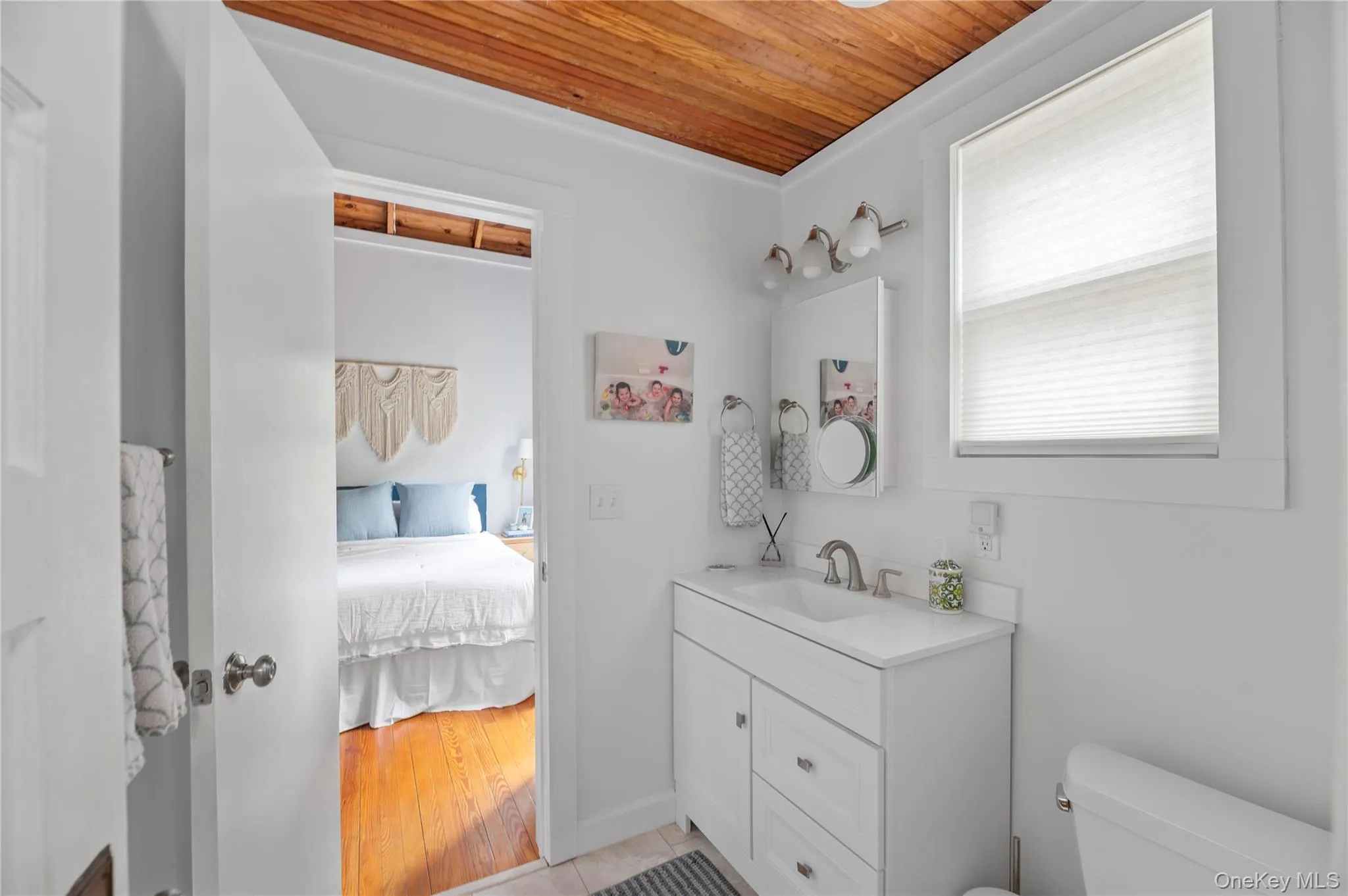 Ensuite bathroom with vanity, wood ceiling, and light tile patterned flooring Ensuite bathroom with vanity, wood ceiling, and light tile patterned flooring