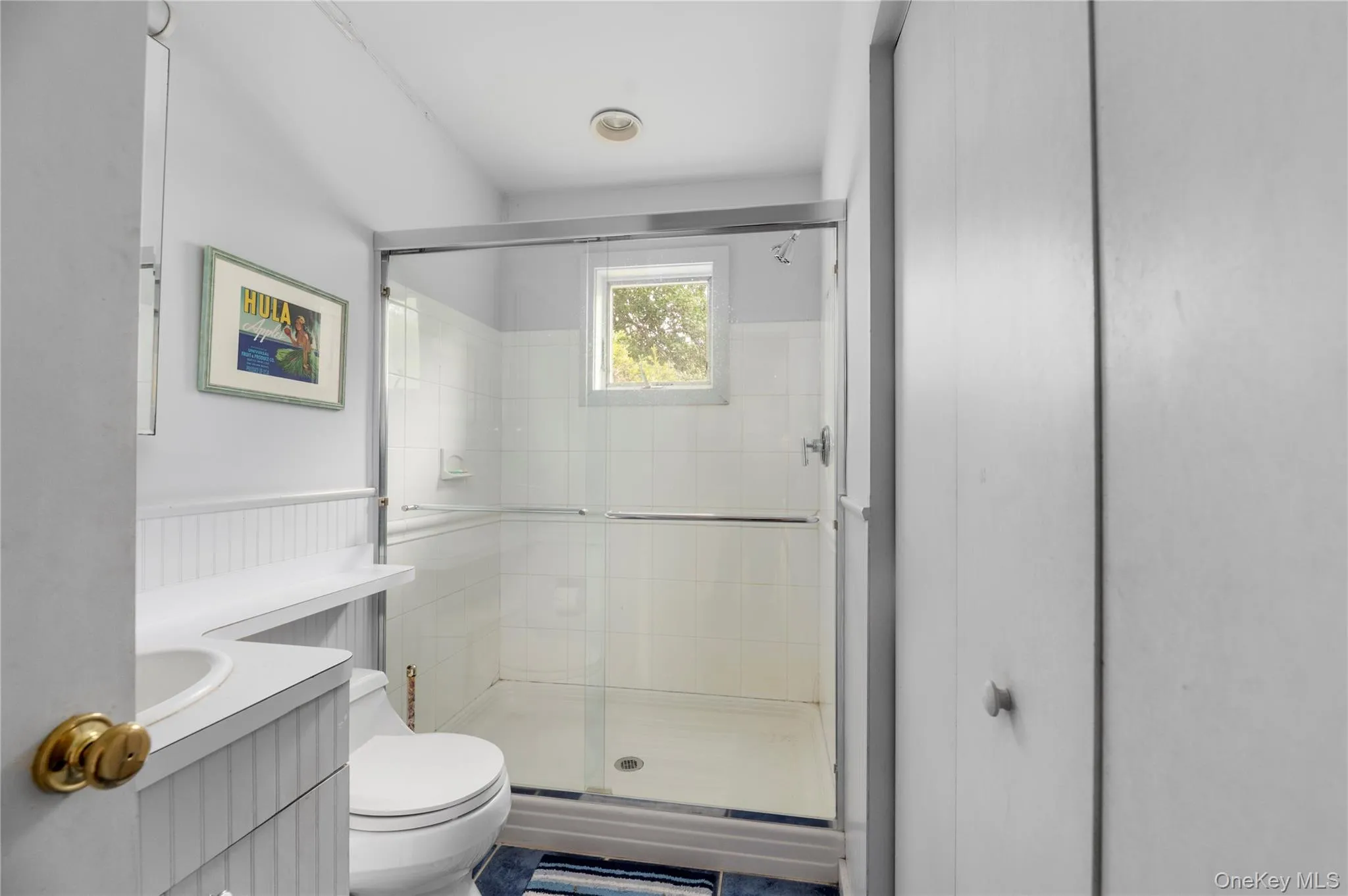 Full bath featuring vanity, a shower stall, and a wainscoted wall Full bath featuring vanity, a shower stall, and a wainscoted wall