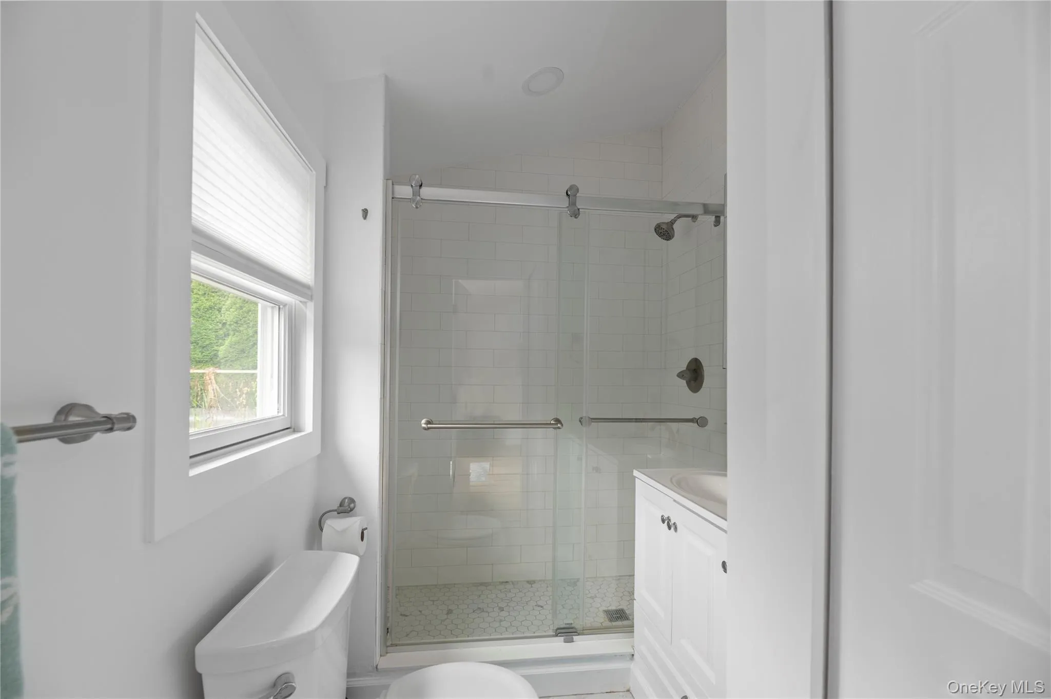 Bathroom with a stall shower, vanity, and lofted ceiling Bathroom with a stall shower, vanity, and lofted ceiling
