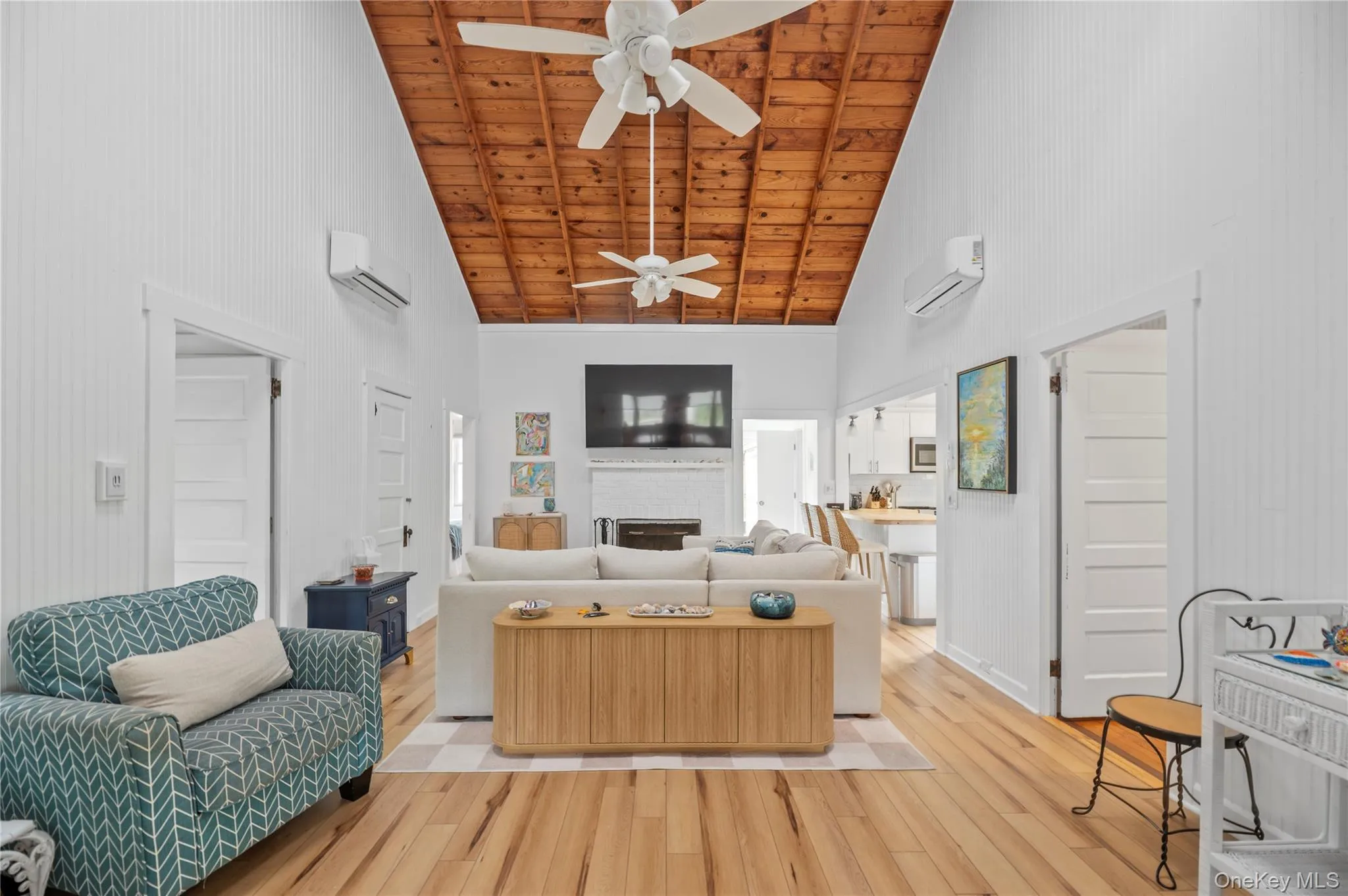 Living room featuring high vaulted ceiling, a fireplace, wood finished floors, and wood ceiling Living room featuring high vaulted ceiling, a fireplace, wood finished floors, and wood ceiling