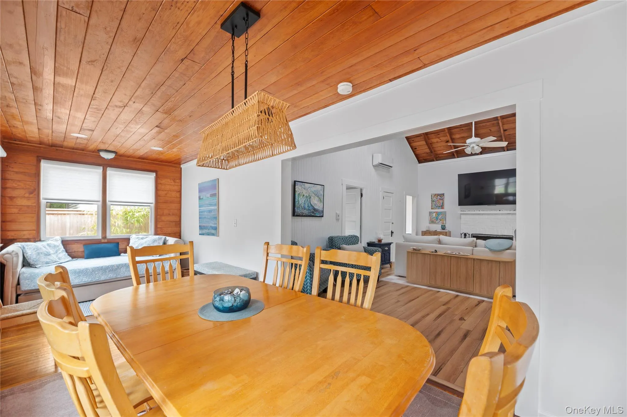Dining room with wood ceiling, a fireplace, wood finished floors, and ceiling fan Dining room with wood ceiling, a fireplace, wood finished floors, and ceiling fan