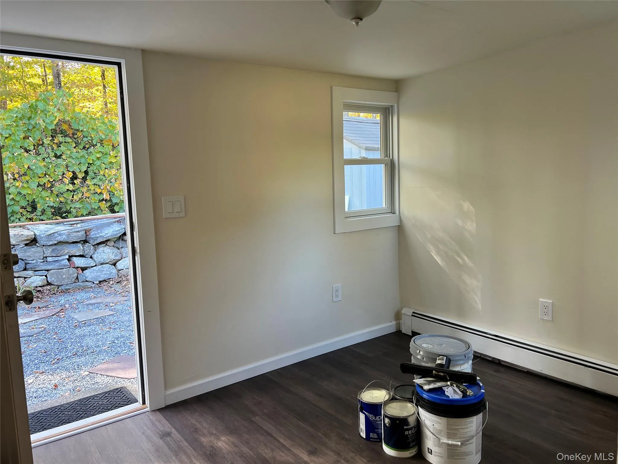 Spare room featuring dark wood finished floors and a baseboard radiator Spare room featuring dark wood finished floors and a baseboard radiator