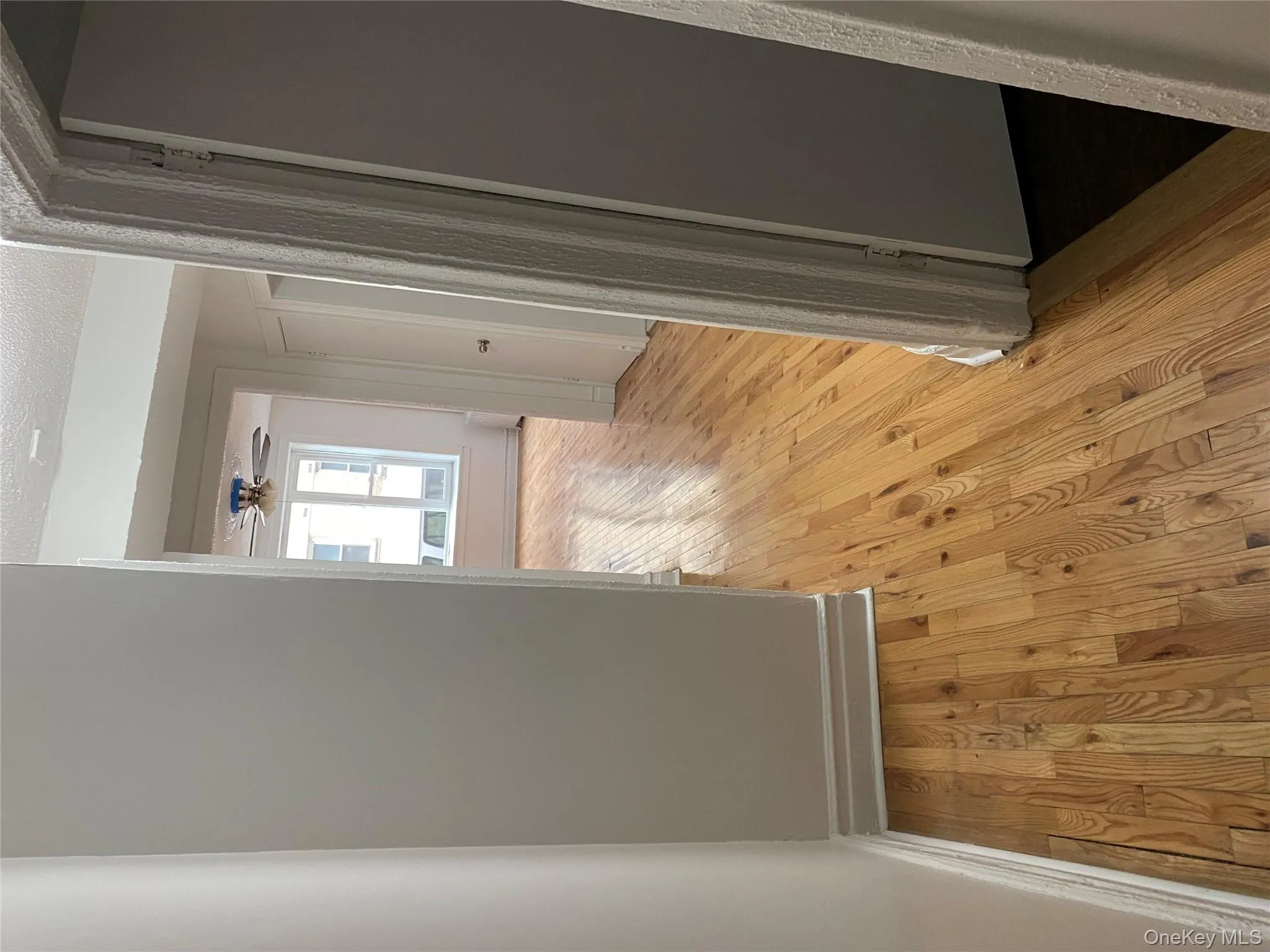 Hall with light wood-type flooring and a textured ceiling Hall with light wood-type flooring and a textured ceiling