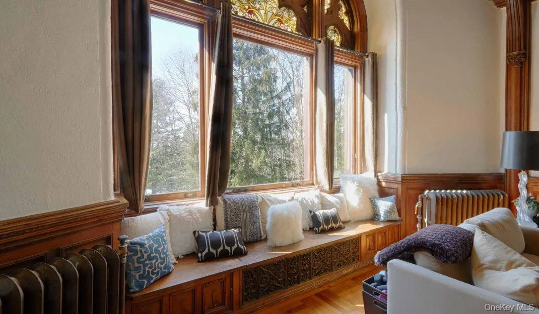 Living area with radiator, a textured wall, and wainscoting Living area with radiator, a textured wall, and wainscoting