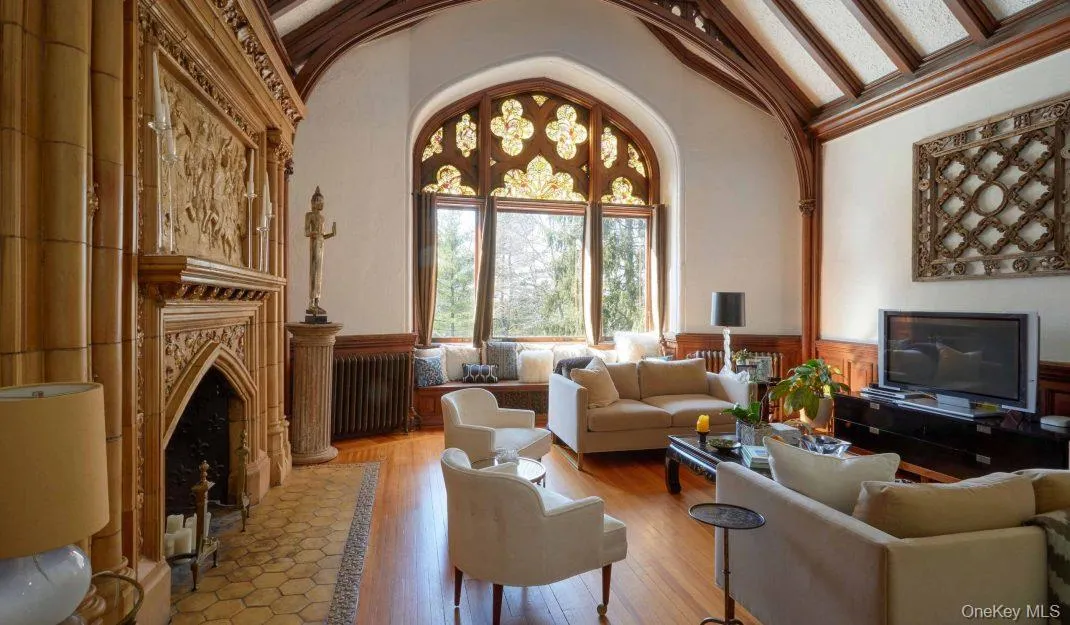 Living area with a wainscoted wall, radiator, wood finished floors, high vaulted ceiling, and a fireplace Living area with a wainscoted wall, radiator, wood finished floors, high vaulted ceiling, and a fireplace