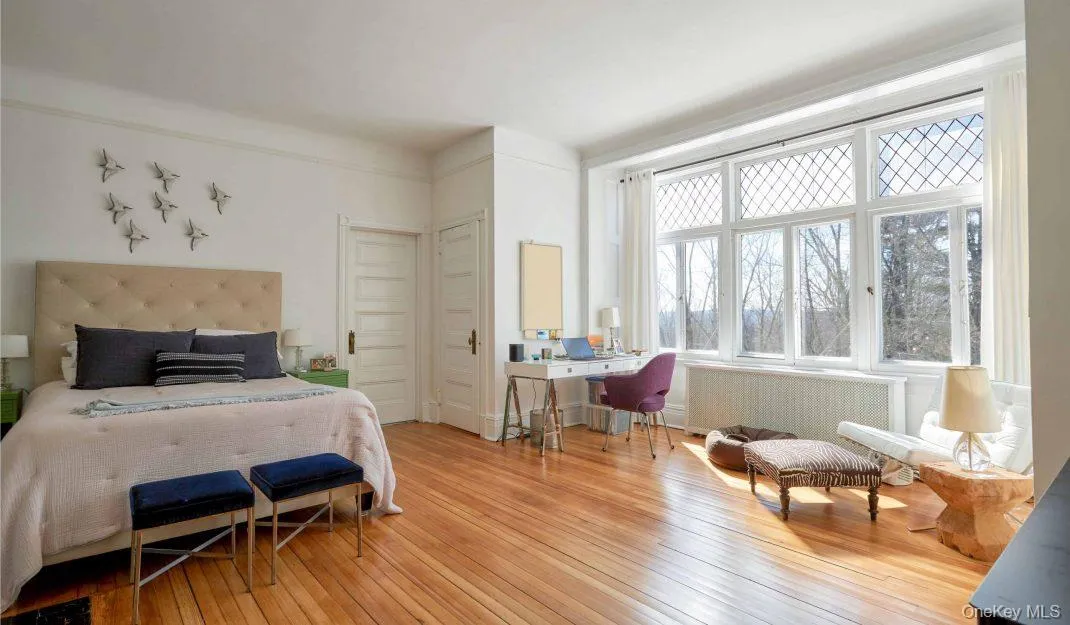 Bedroom with radiator, an office area, and hardwood / wood-style floors Bedroom with radiator, an office area, and hardwood / wood-style floors