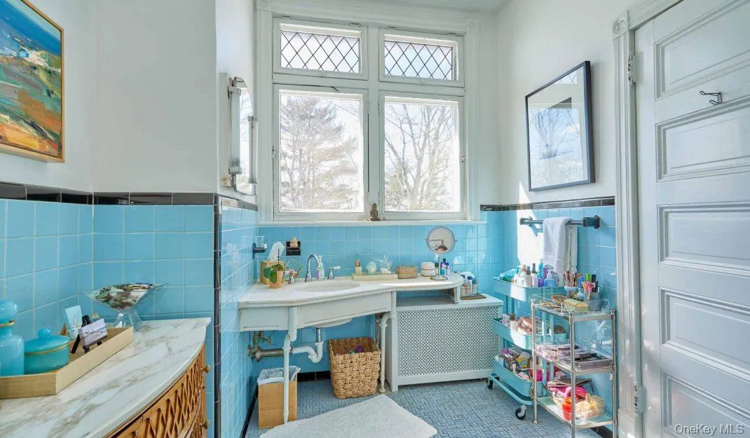 Bathroom featuring tile walls, vanity, a wainscoted wall, radiator, and tile patterned flooring Bathroom featuring tile walls, vanity, a wainscoted wall, radiator, and tile patterned flooring