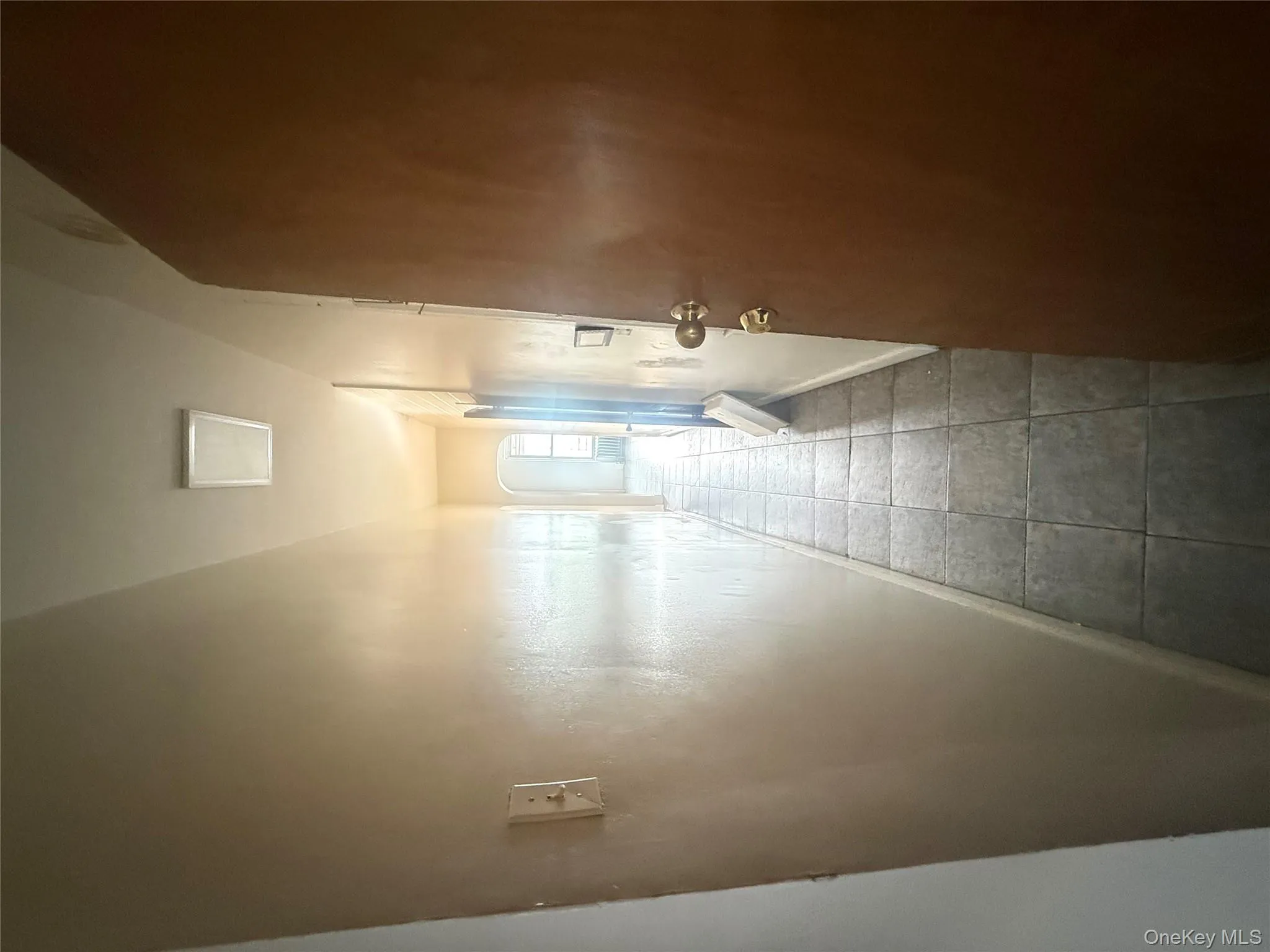 Hallway featuring arched walkways and baseboards Hallway featuring arched walkways and baseboards