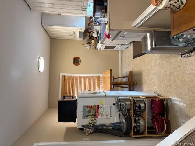 Kitchen with white cabinetry, light countertops, refrigerator, and range Kitchen with white cabinetry, light countertops, refrigerator, and range