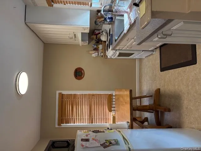 Kitchen featuring refrigerator, range, white cabinets, and exhaust hood Kitchen featuring refrigerator, range, white cabinets, and exhaust hood