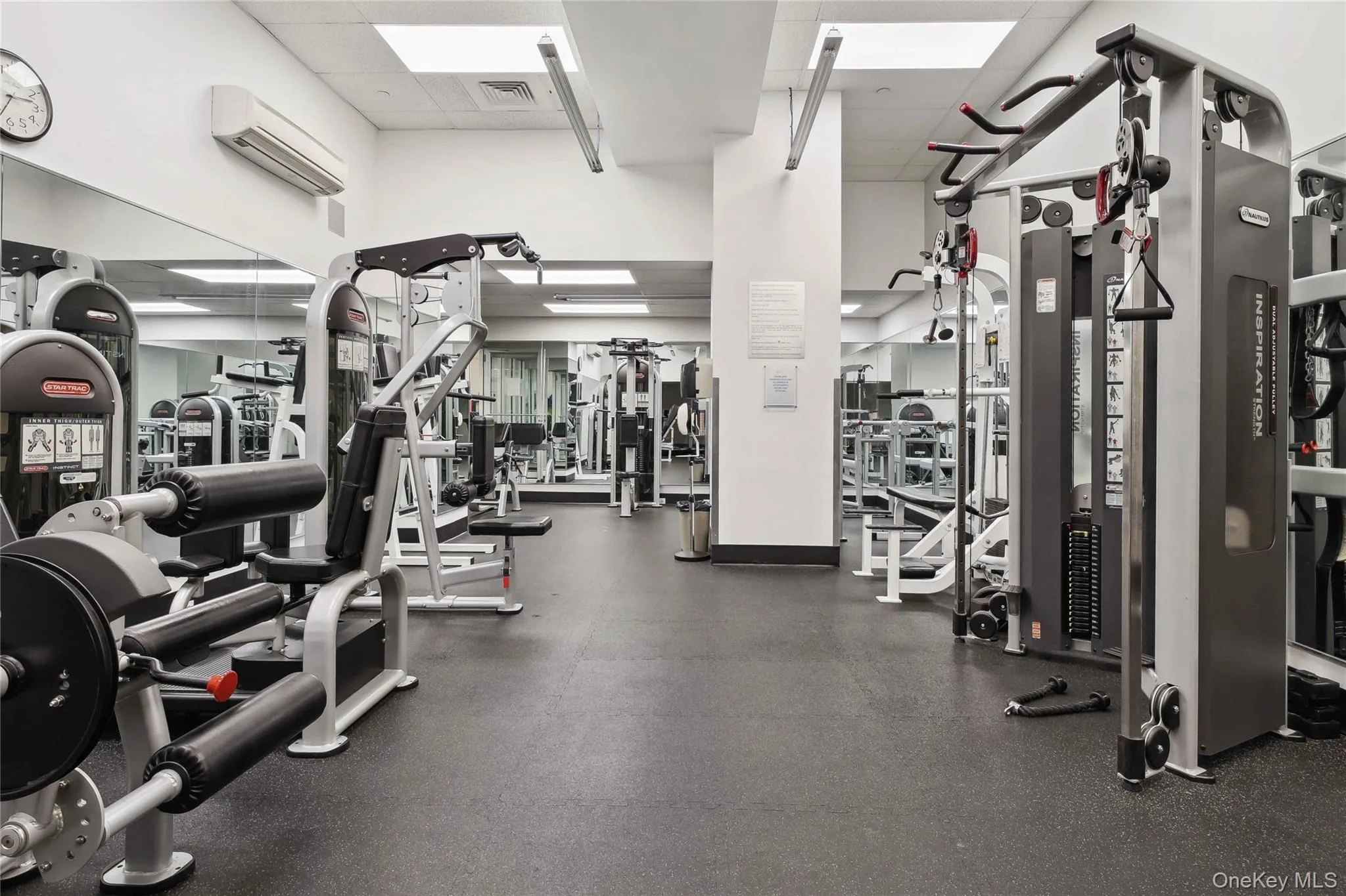 Gym with a paneled ceiling and a wall mounted air conditioner Gym with a paneled ceiling and a wall mounted air conditioner