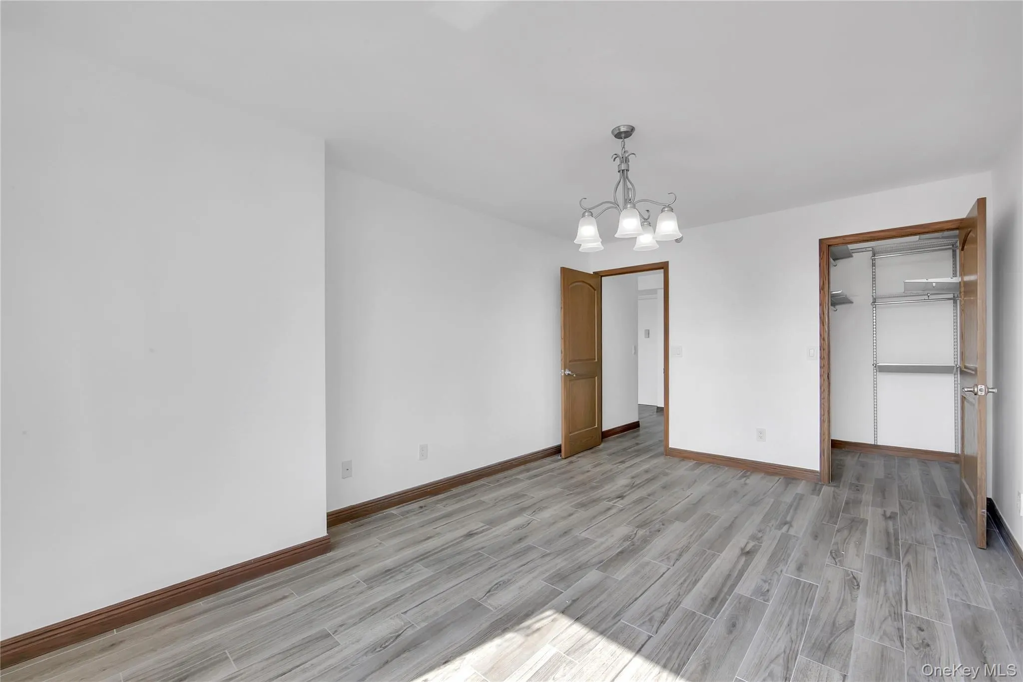 Unfurnished dining area with a chandelier and light wood-style flooring Unfurnished dining area with a chandelier and light wood-style flooring