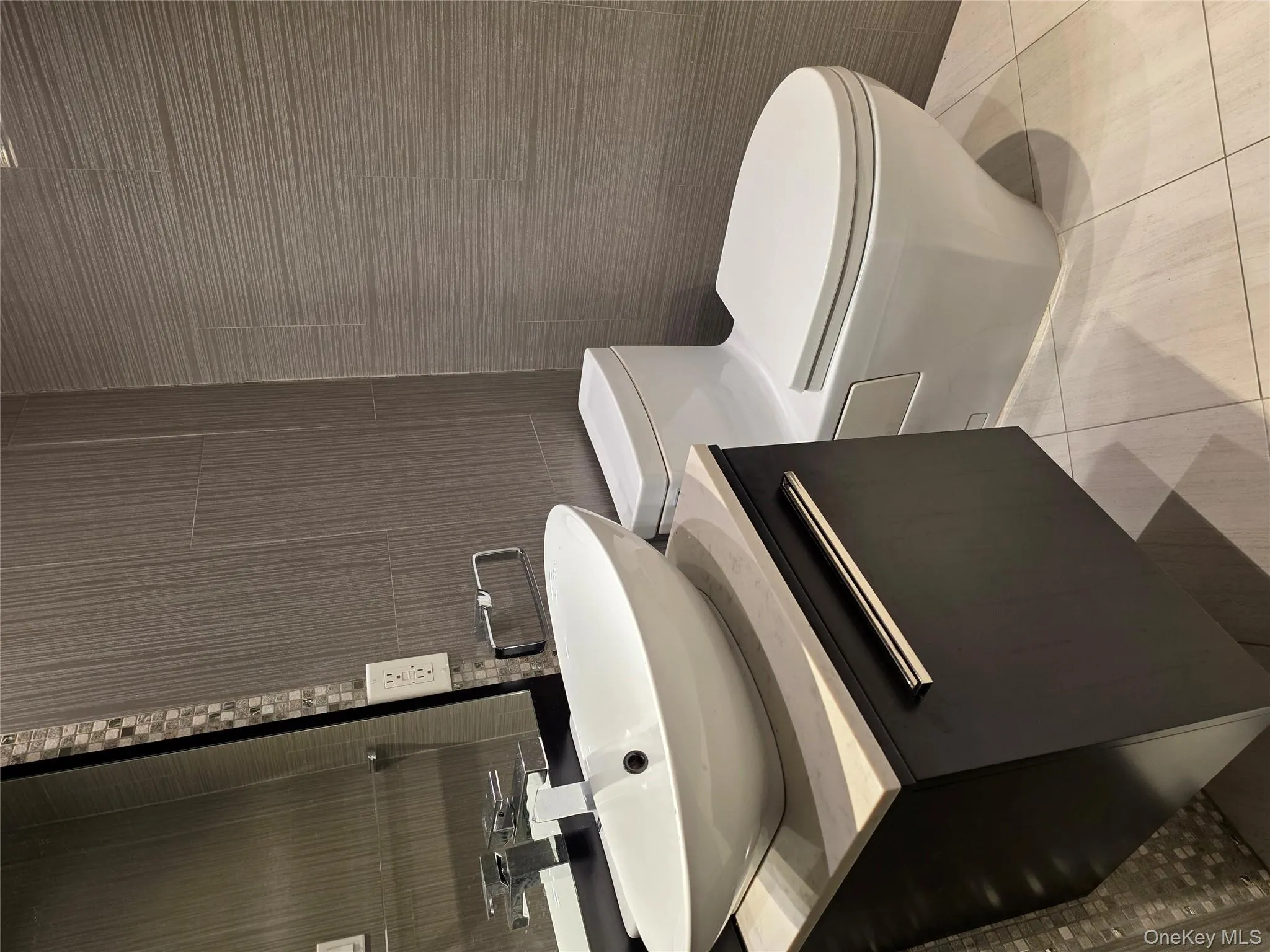 Half bath featuring light tile patterned flooring, vanity, and tile walls Half bath featuring light tile patterned flooring, vanity, and tile walls