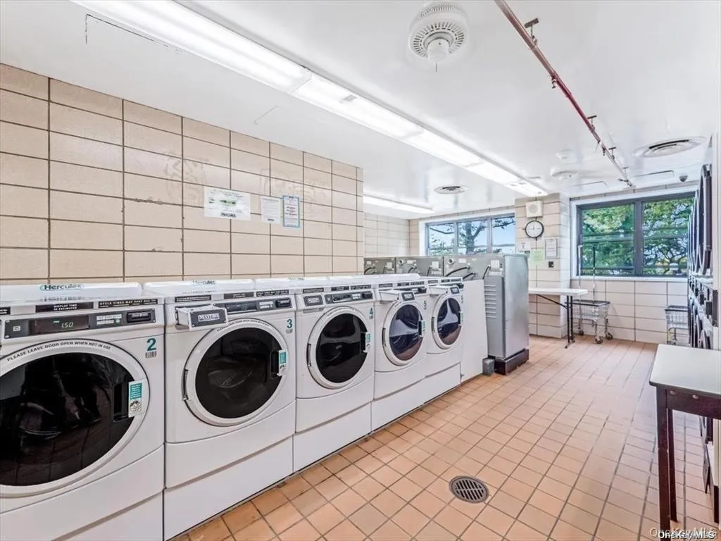 Shared laundry with independent washer and dryer and tile walls Shared laundry with independent washer and dryer and tile walls