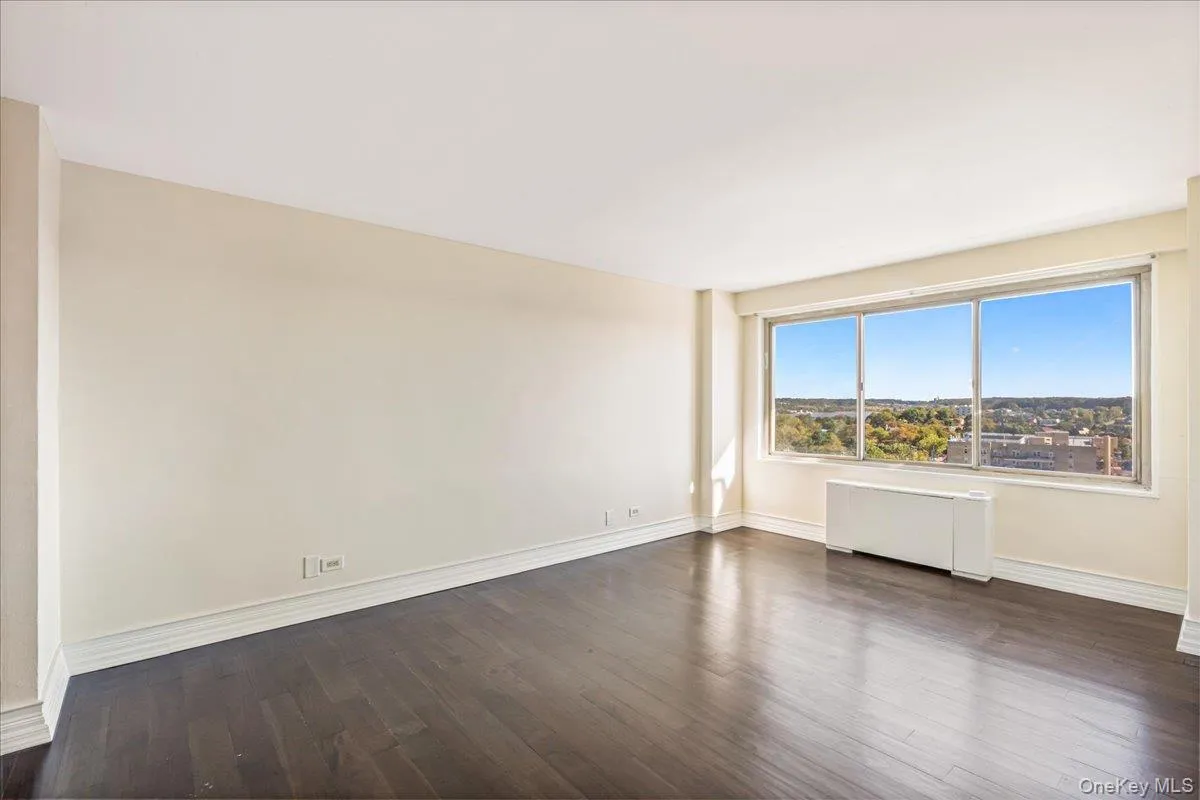 Unfurnished room with dark wood-style floors and radiator heating unit Unfurnished room with dark wood-style floors and radiator heating unit