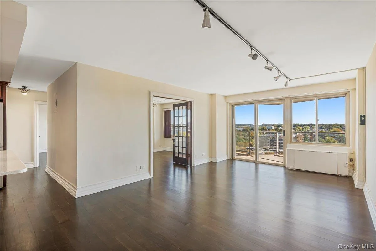 Unfurnished room featuring rail lighting and dark wood finished floors Unfurnished room featuring rail lighting and dark wood finished floors