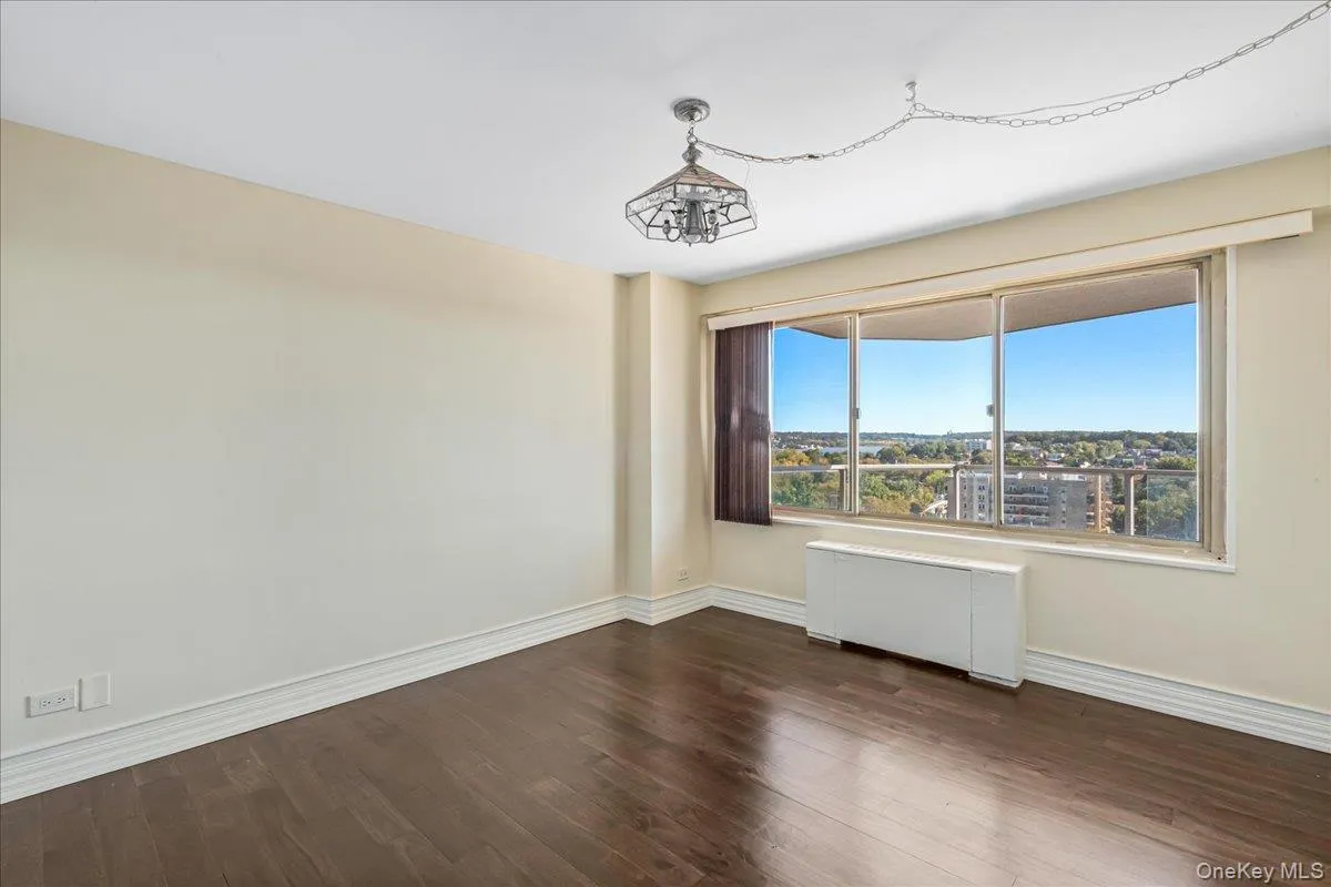 Unfurnished room with dark wood-type flooring and radiator heating unit Unfurnished room with dark wood-type flooring and radiator heating unit