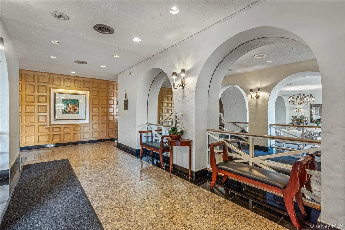 Building lobby featuring a textured ceiling, recessed lighting, and a textured wall Building lobby featuring a textured ceiling, recessed lighting, and a textured wall