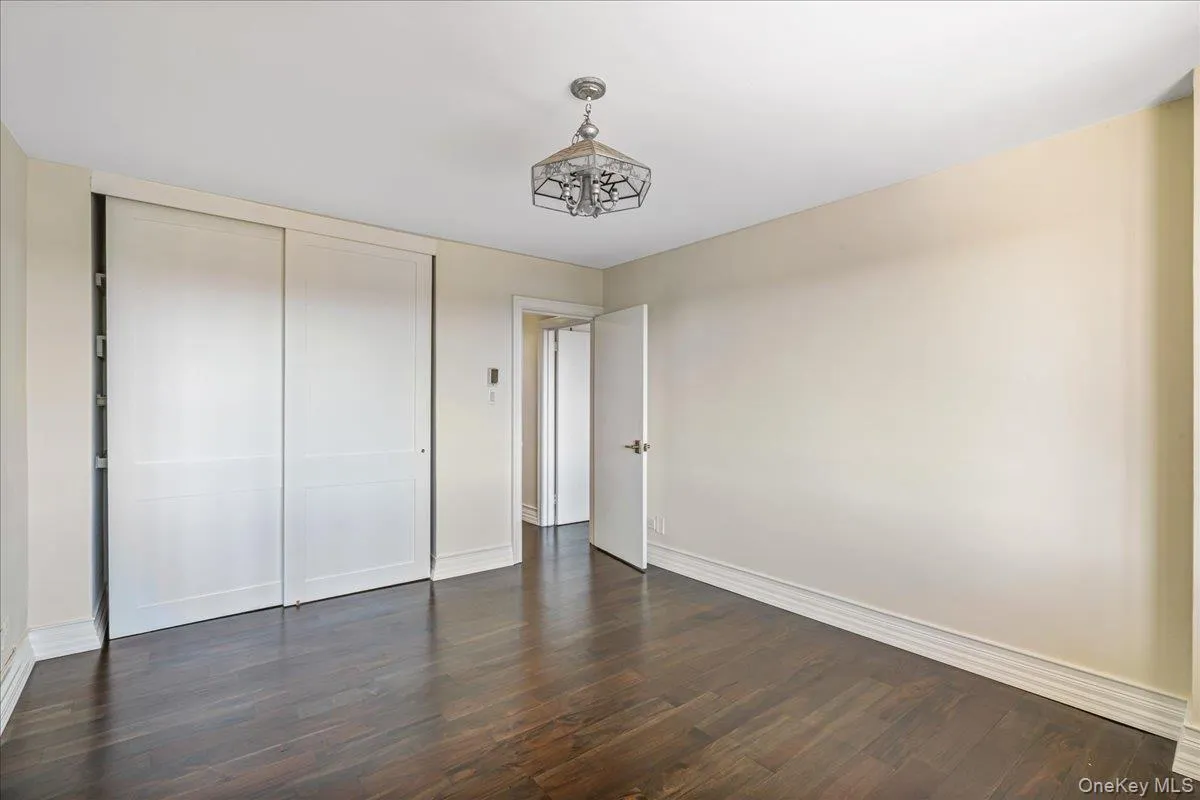 Unfurnished bedroom featuring dark wood finished floors and a closet Unfurnished bedroom featuring dark wood finished floors and a closet