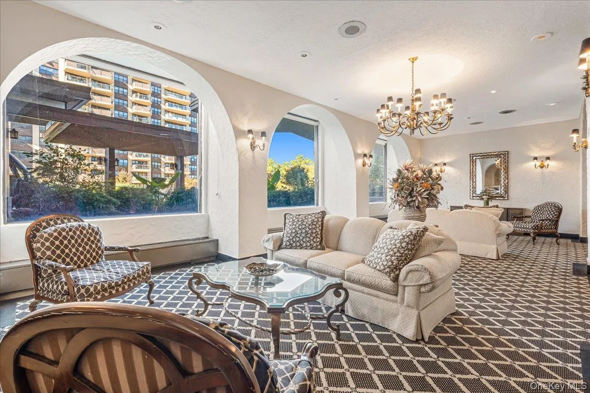 Living room featuring a textured wall, carpet flooring, a textured ceiling, a chandelier, and recessed lighting Living room featuring a textured wall, carpet flooring, a textured ceiling, a chandelier, and recessed lighting
