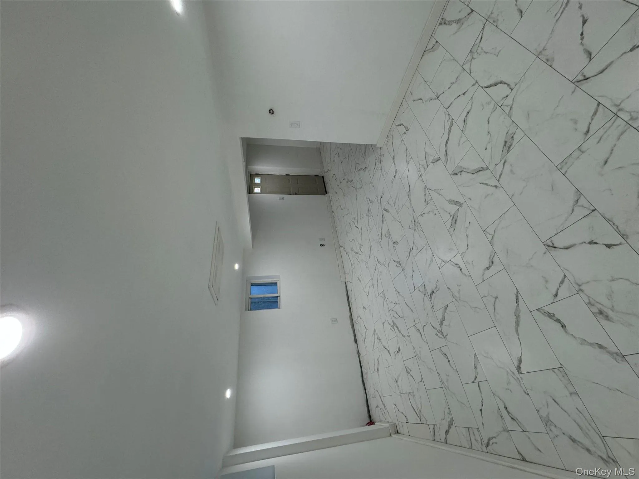 Finished basement with light marble finish floors and recessed lighting Finished basement with light marble finish floors and recessed lighting