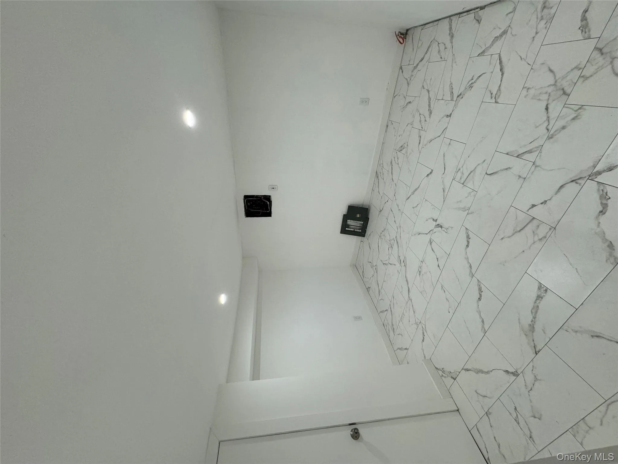 Finished basement featuring light marble finish flooring and recessed lighting Finished basement featuring light marble finish flooring and recessed lighting