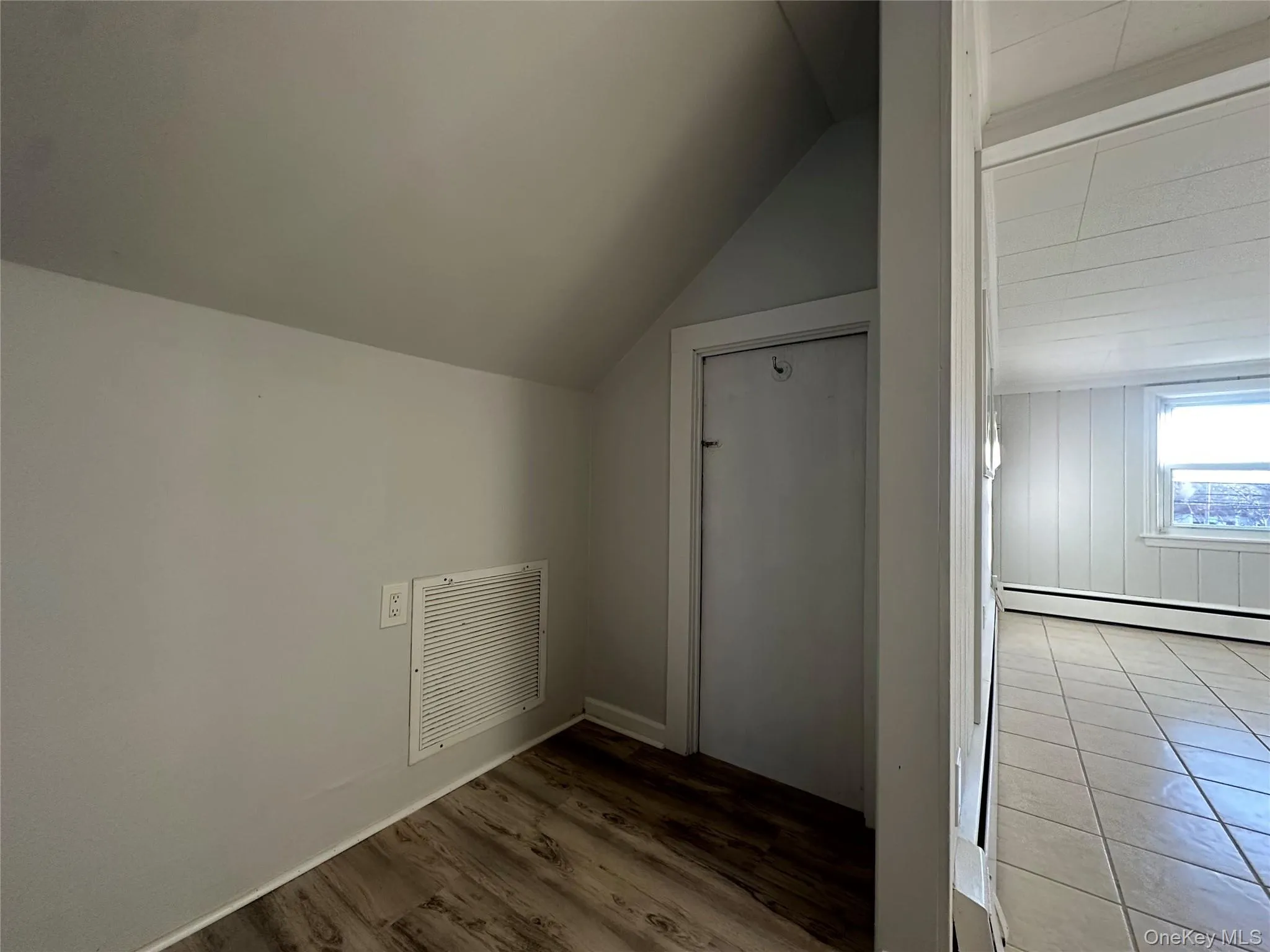 Bonus room with vaulted ceiling, a baseboard radiator, and wood finished floors Bonus room with vaulted ceiling, a baseboard radiator, and wood finished floors