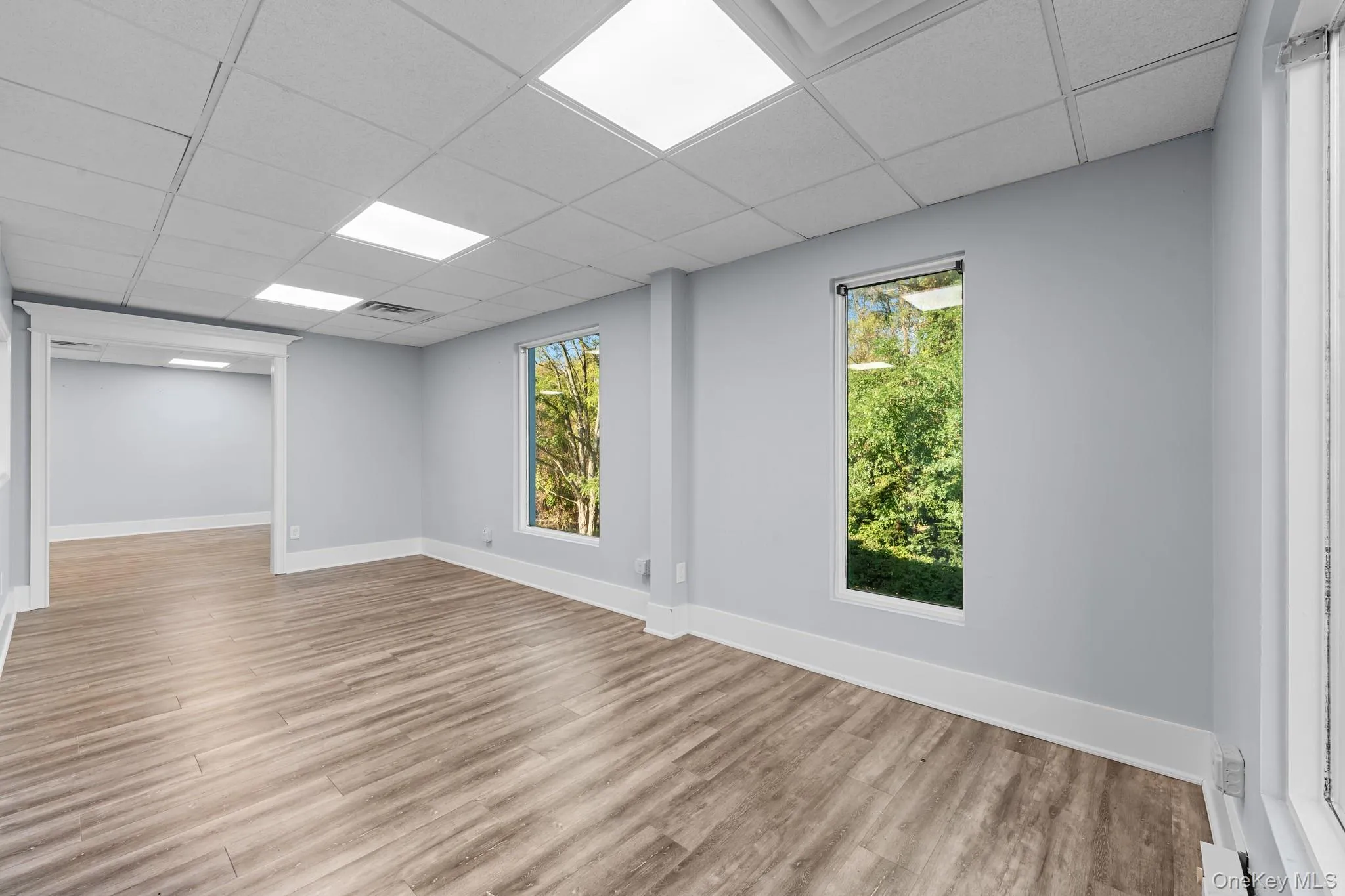 Main with a drop ceiling and light wood-style flooring Main with a drop ceiling and light wood-style flooring