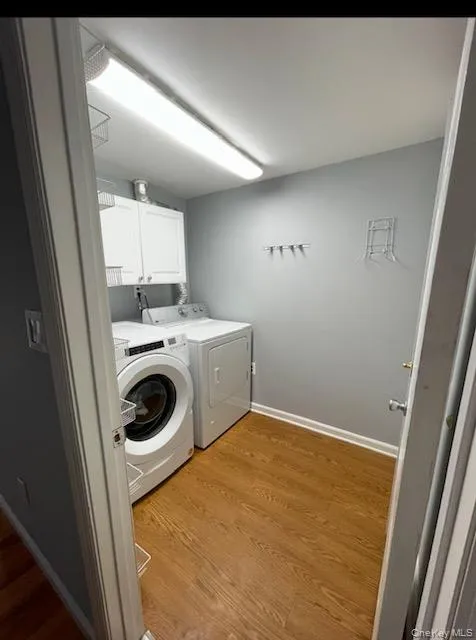 Full Laundry room with Washer & Dryer, storage, closet, wood floor, and baseboard Full Laundry room with Washer & Dryer, storage, closet, wood floor, and baseboard