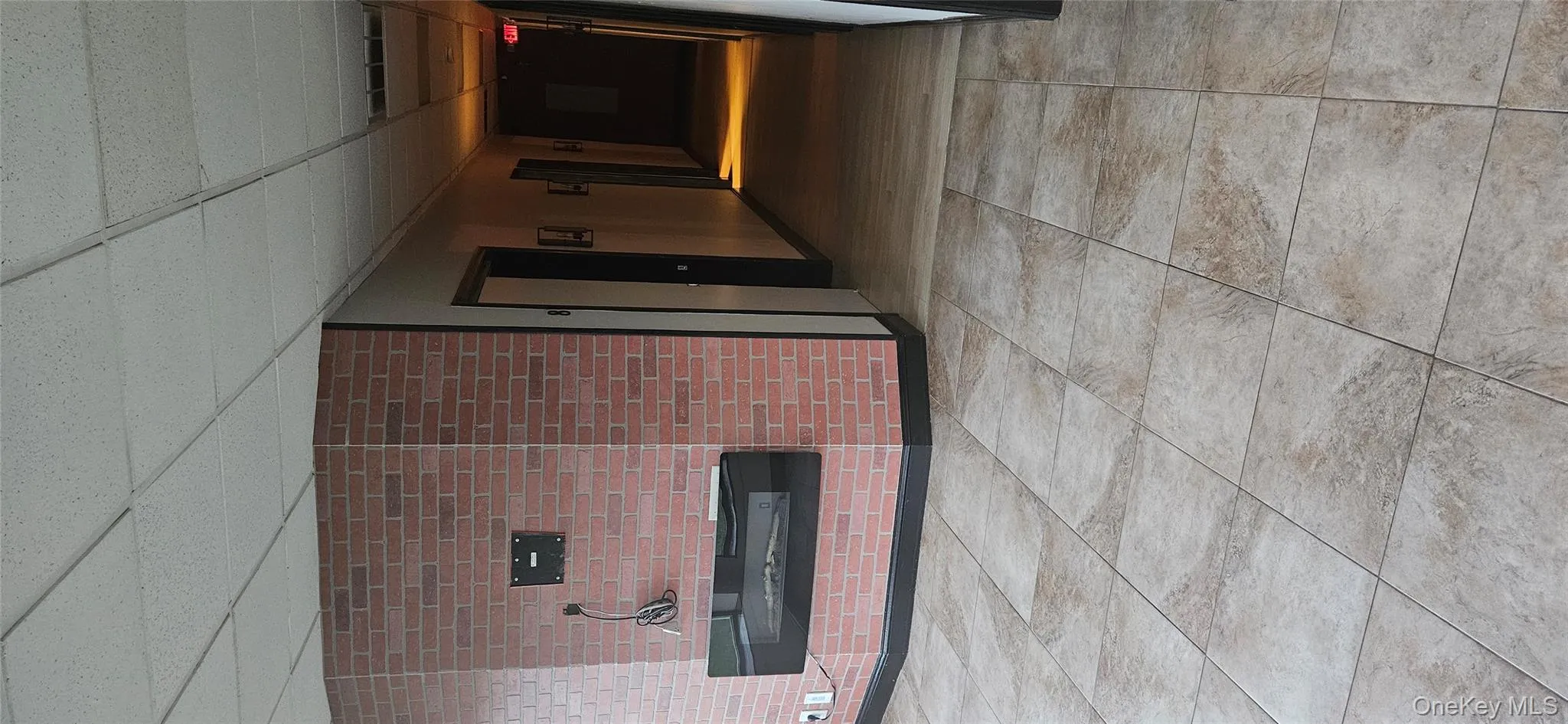 Hallway featuring a drop ceiling and tile patterned floors Hallway featuring a drop ceiling and tile patterned floors