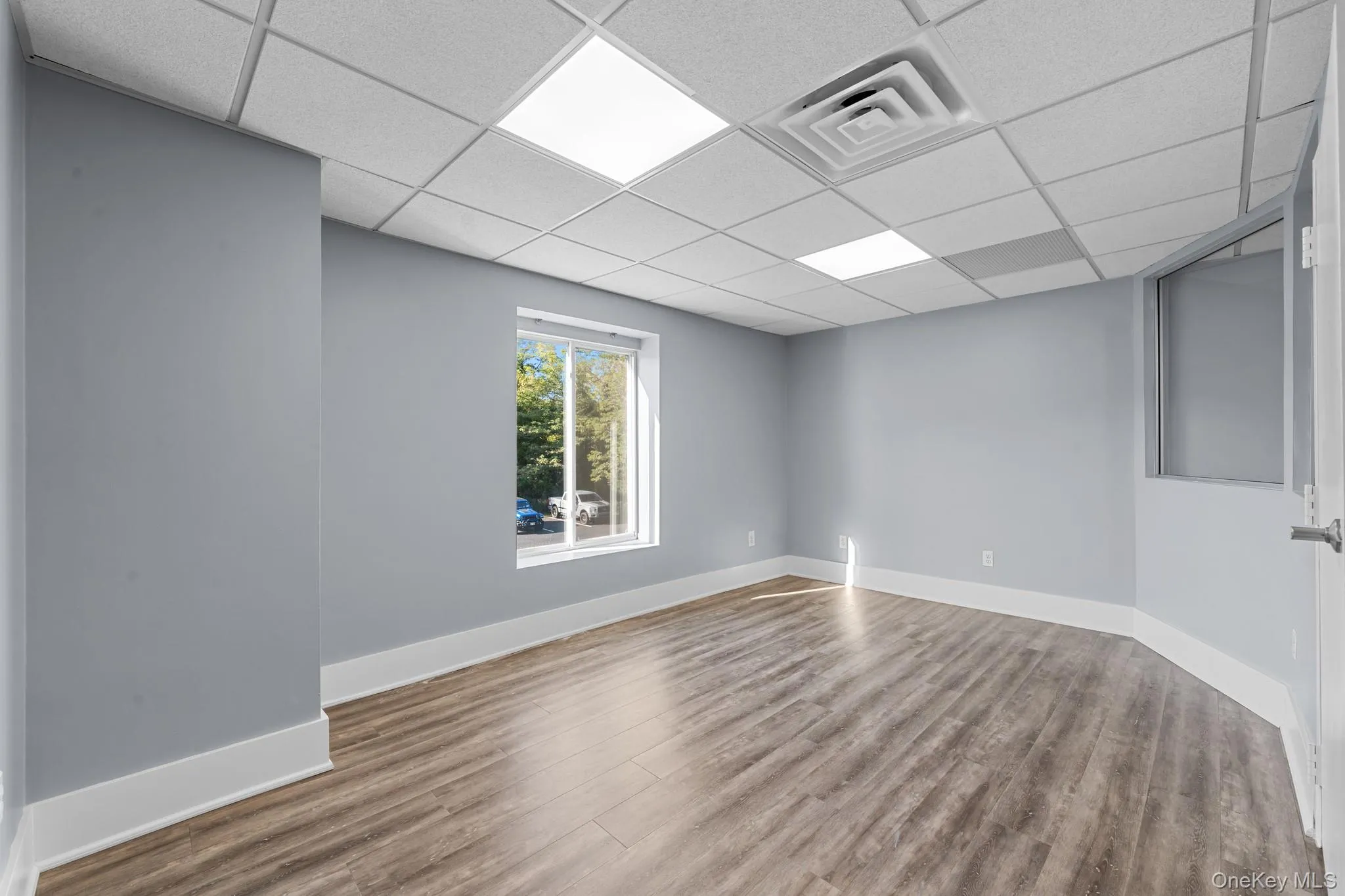 Private office with wood finished floors and a paneled ceiling Private office with wood finished floors and a paneled ceiling