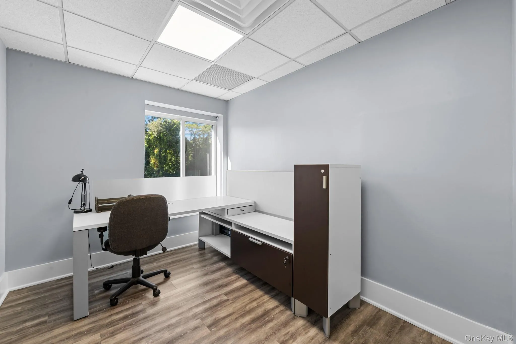 Private office with light wood finished floors and a drop ceiling Private office with light wood finished floors and a drop ceiling
