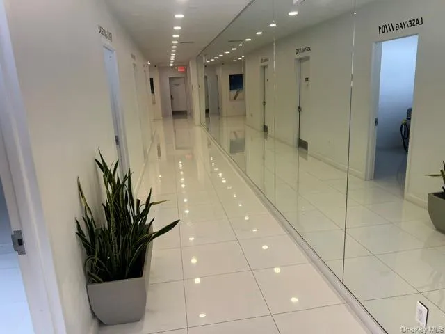 Hall with light tile patterned flooring, recessed lighting, and elevator Hall with light tile patterned flooring, recessed lighting, and elevator