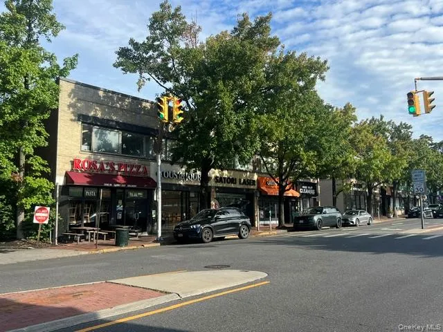 View of asphalt street with traffic lights, sidewalks, traffic signs, and curbs View of asphalt street with traffic lights, sidewalks, traffic signs, and curbs