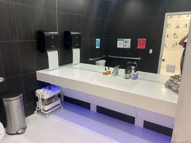 Bathroom featuring tile walls, tile patterned floors, and vanity Bathroom featuring tile walls, tile patterned floors, and vanity