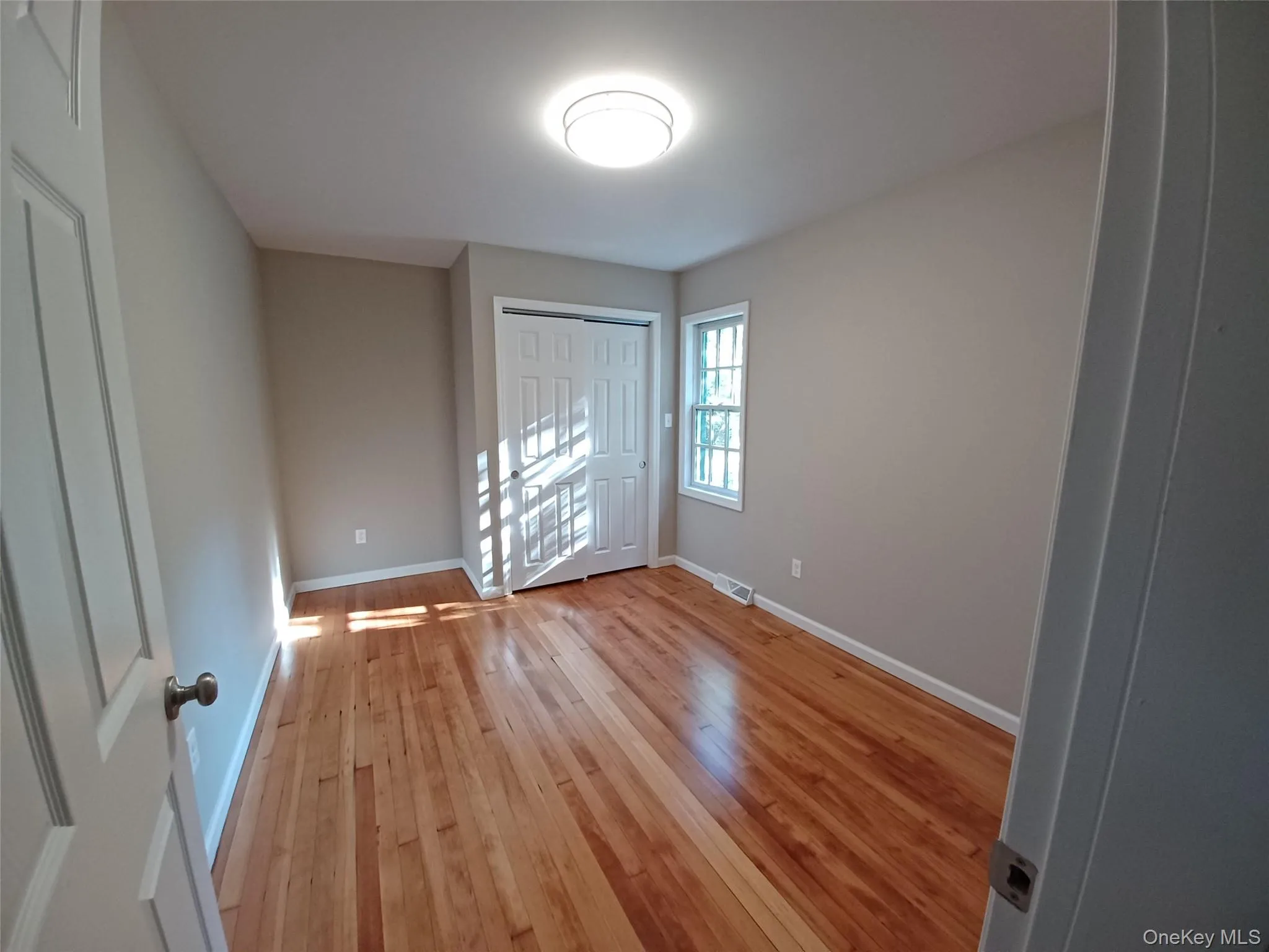 Bedroom with light wood-type flooring and baseboards Bedroom with light wood-type flooring and baseboards