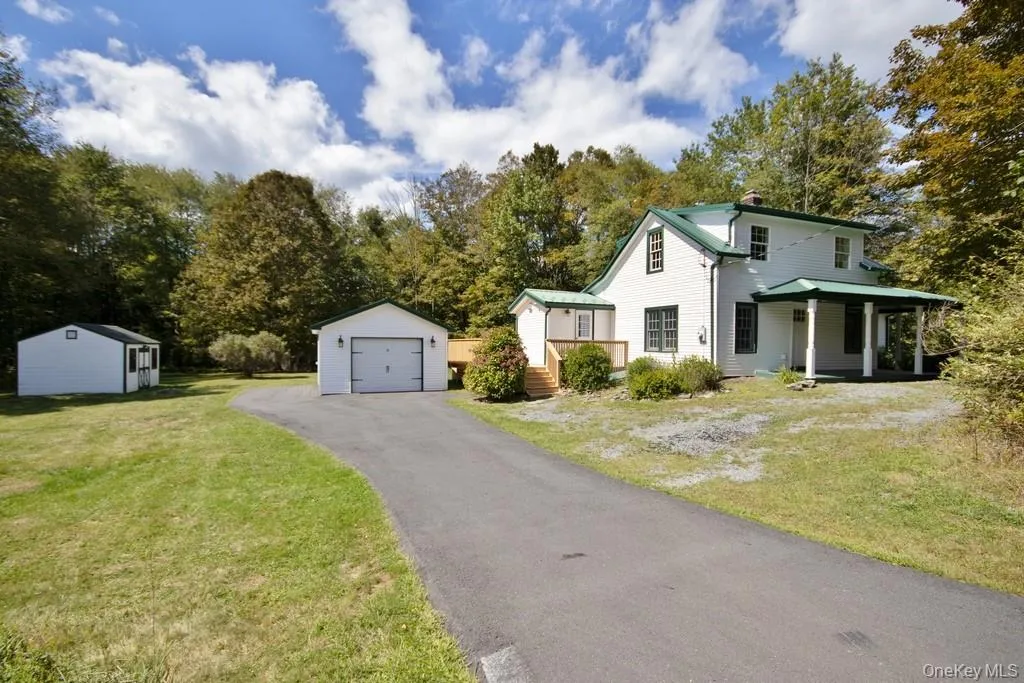View of front of property featuring a shed and 1 car garage, a front yard, and driveway View of front of property featuring a shed and 1 car garage, a front yard, and driveway