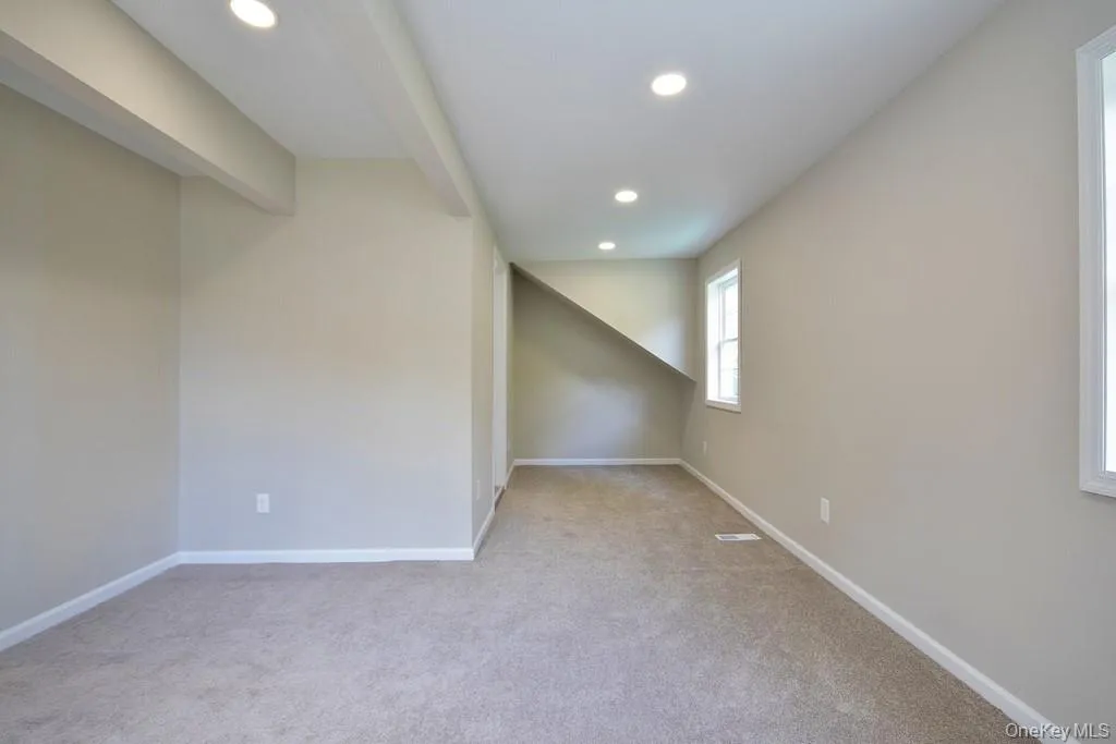 Primary bedroom with recessed lighting, light colored carpet, and beam ceiling Primary bedroom with recessed lighting, light colored carpet, and beam ceiling