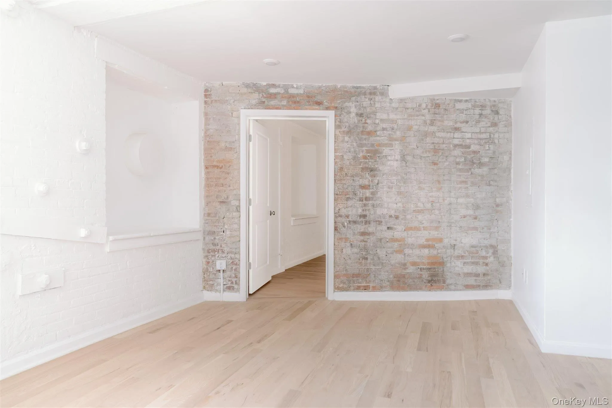 Empty room with brick wall and wood finished floors Empty room with brick wall and wood finished floors