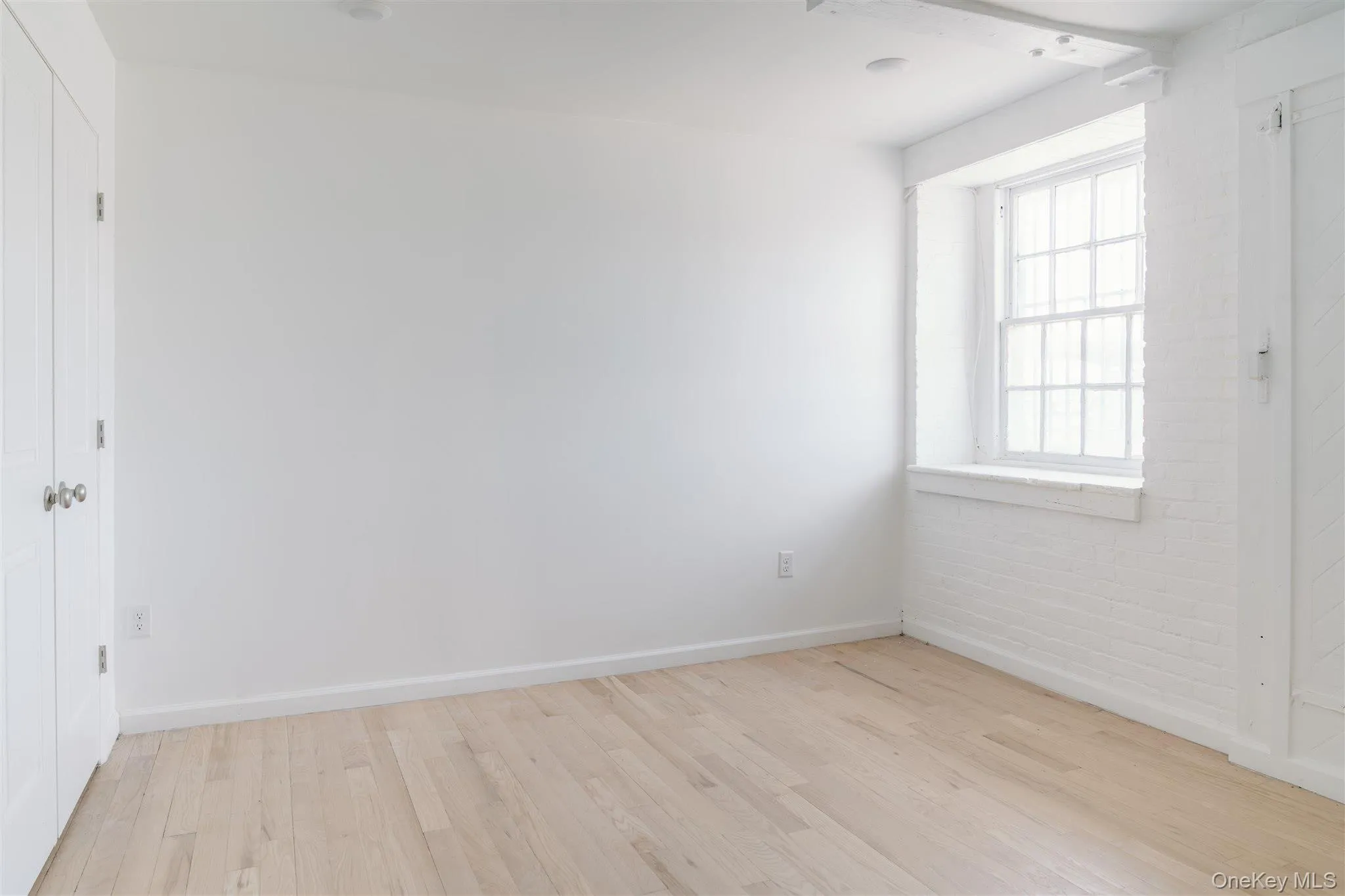 Spare room with light wood finished floors and baseboards Spare room with light wood finished floors and baseboards