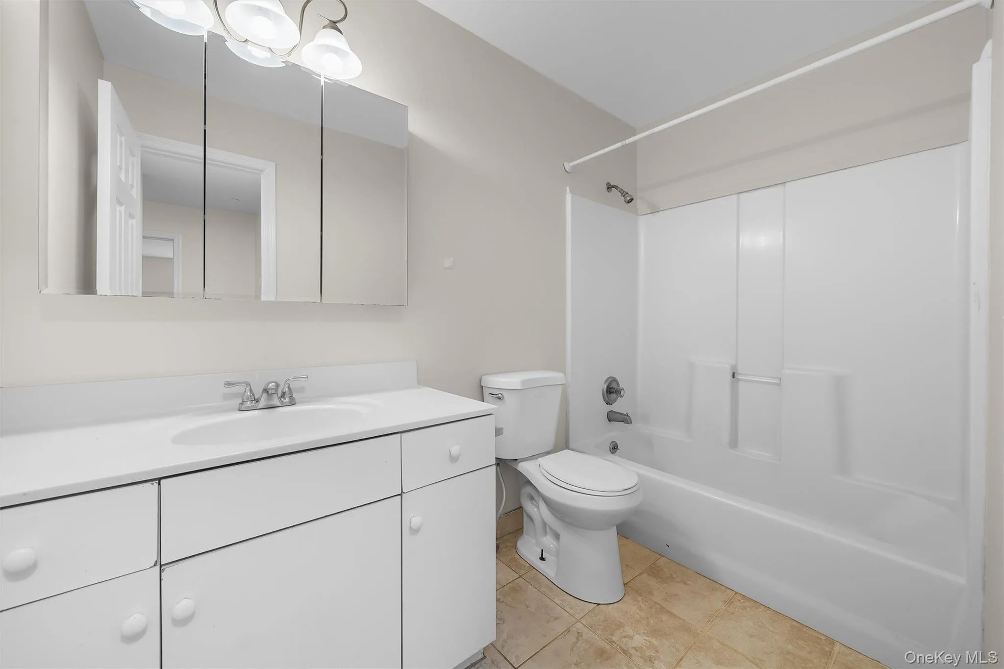 Bathroom with tile patterned floors, bathing tub / shower combination, toilet, and vanity Bathroom with tile patterned floors, bathing tub / shower combination, toilet, and vanity