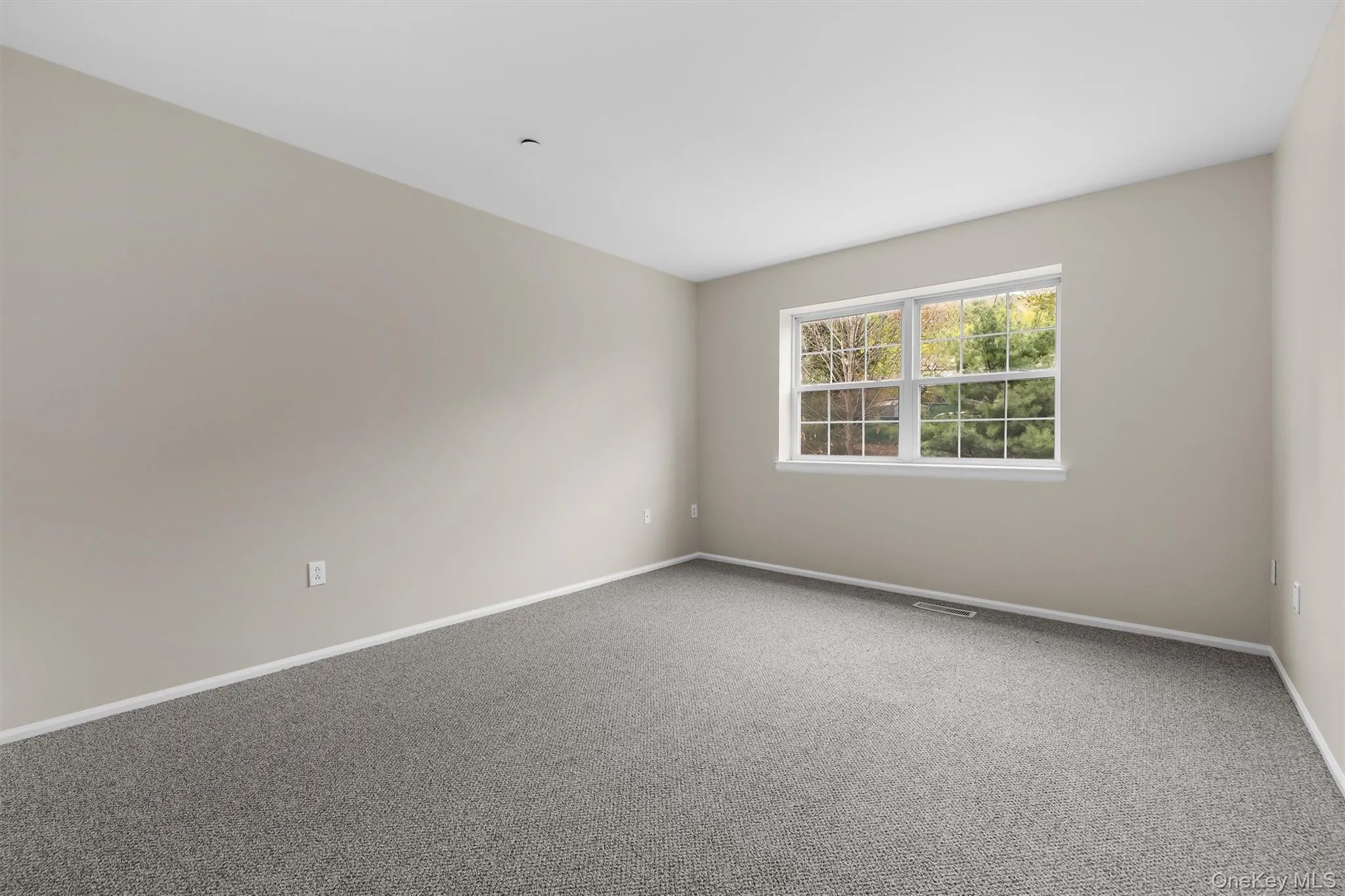 Carpeted empty room featuring baseboards and visible vents Carpeted empty room featuring baseboards and visible vents