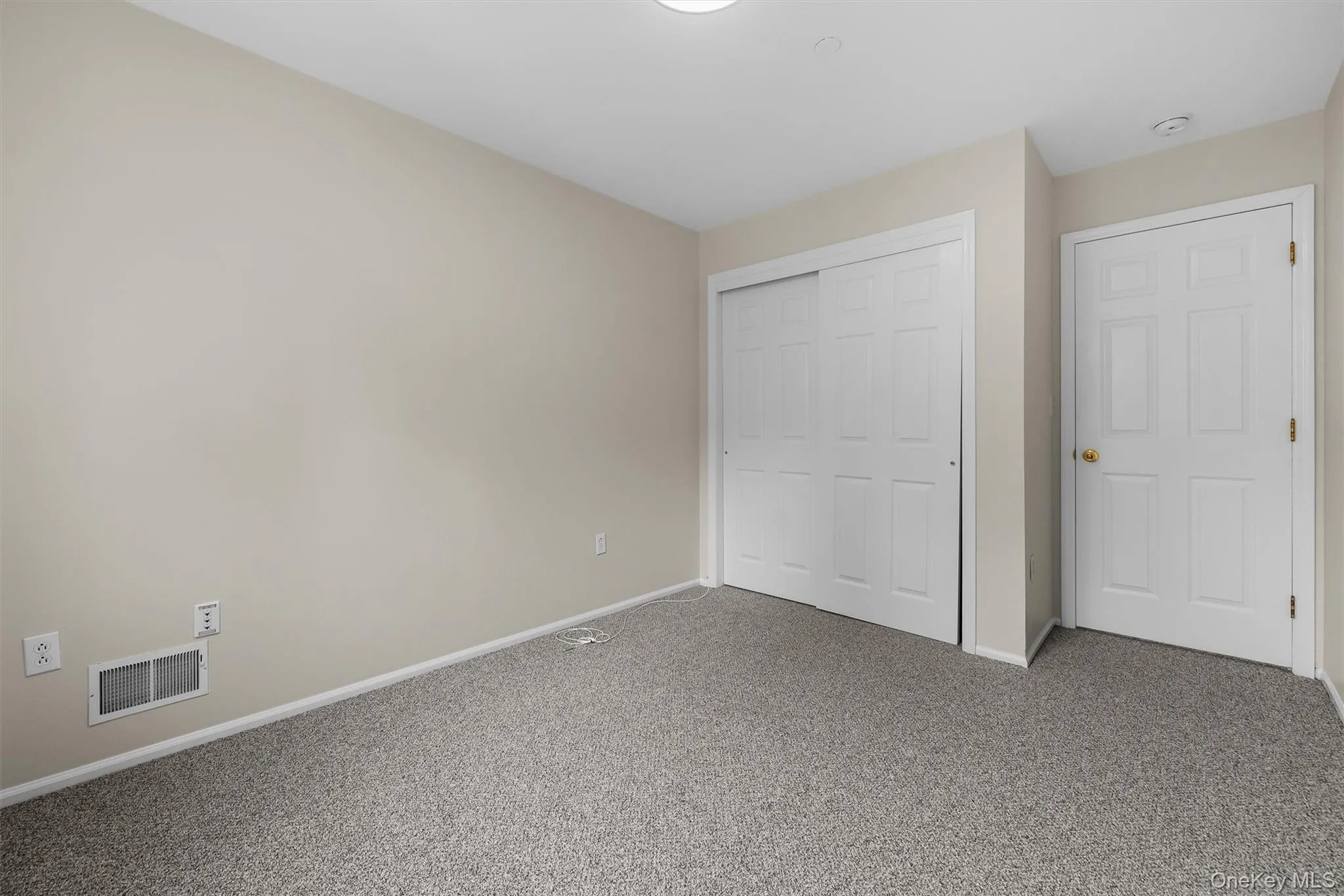 Unfurnished bedroom featuring baseboards, visible vents, carpet floors, and a closet Unfurnished bedroom featuring baseboards, visible vents, carpet floors, and a closet