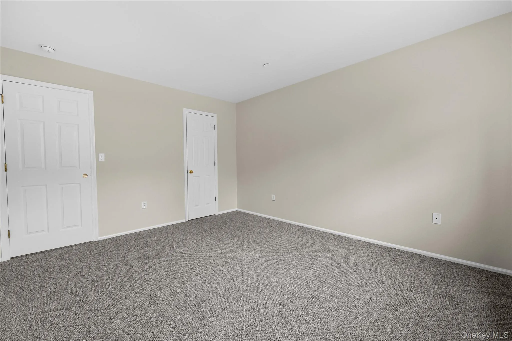 Unfurnished room featuring dark carpet and baseboards Unfurnished room featuring dark carpet and baseboards