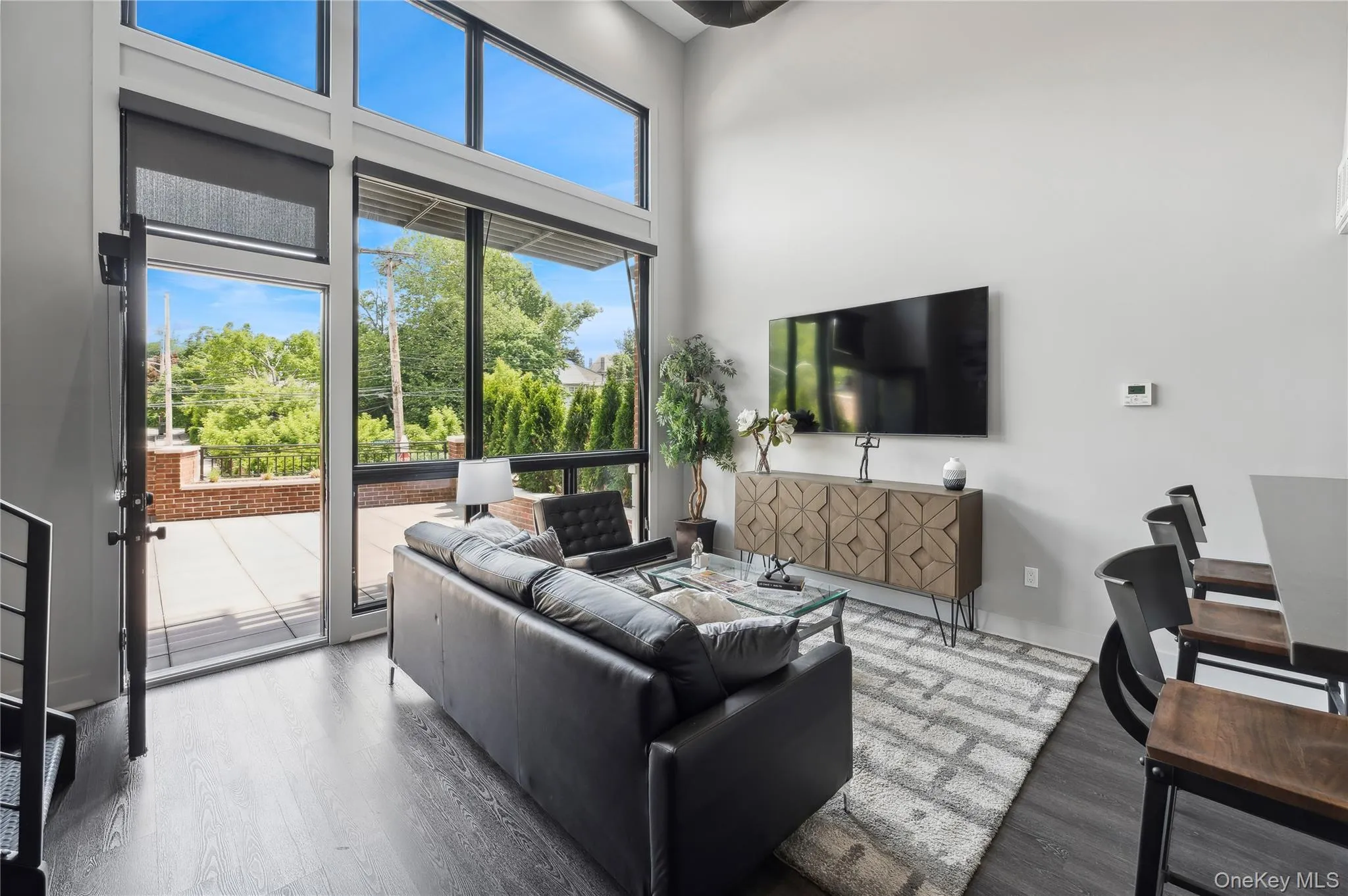 Living room featuring wood finished floors and a towering ceiling Living room featuring wood finished floors and a towering ceiling