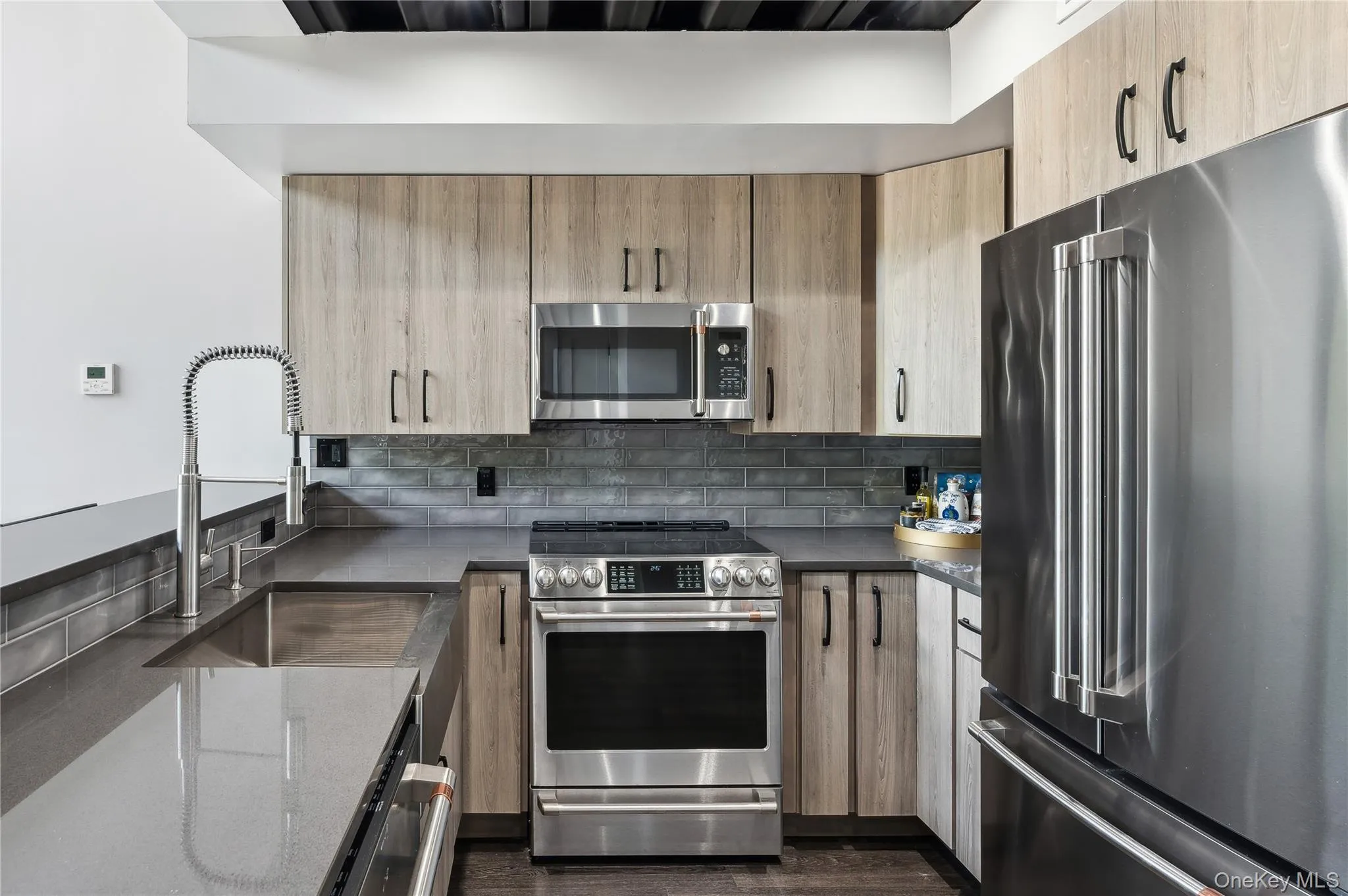 Kitchen featuring stainless steel appliances, tasteful backsplash, and light brown cabinets Kitchen featuring stainless steel appliances, tasteful backsplash, and light brown cabinets