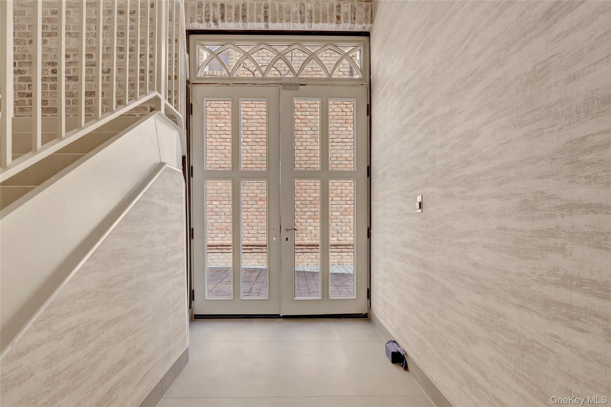 Doorway featuring tile patterned flooring and a towering ceiling Doorway featuring tile patterned flooring and a towering ceiling