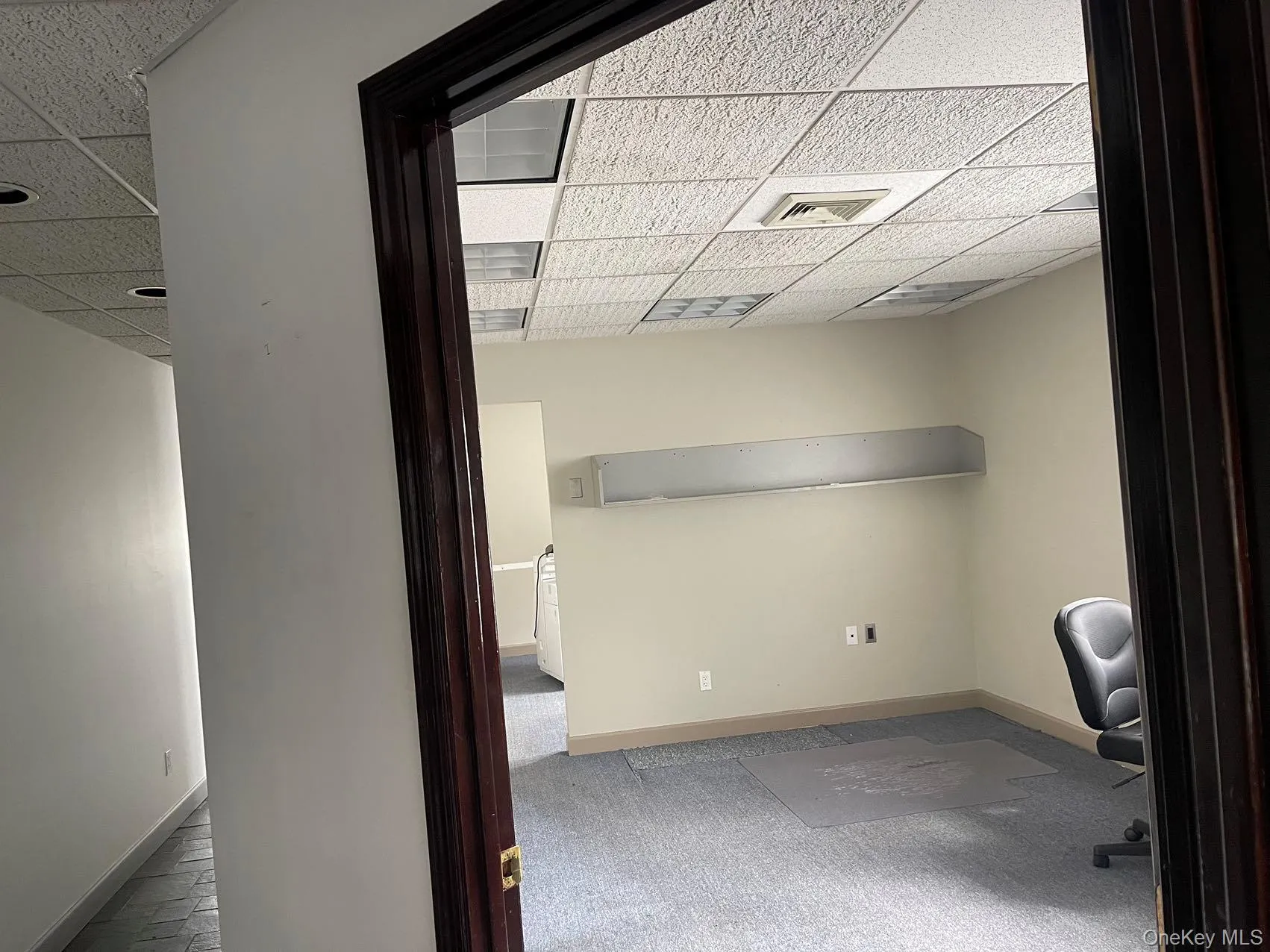 Unfurnished office with a drop ceiling and carpet Unfurnished office with a drop ceiling and carpet