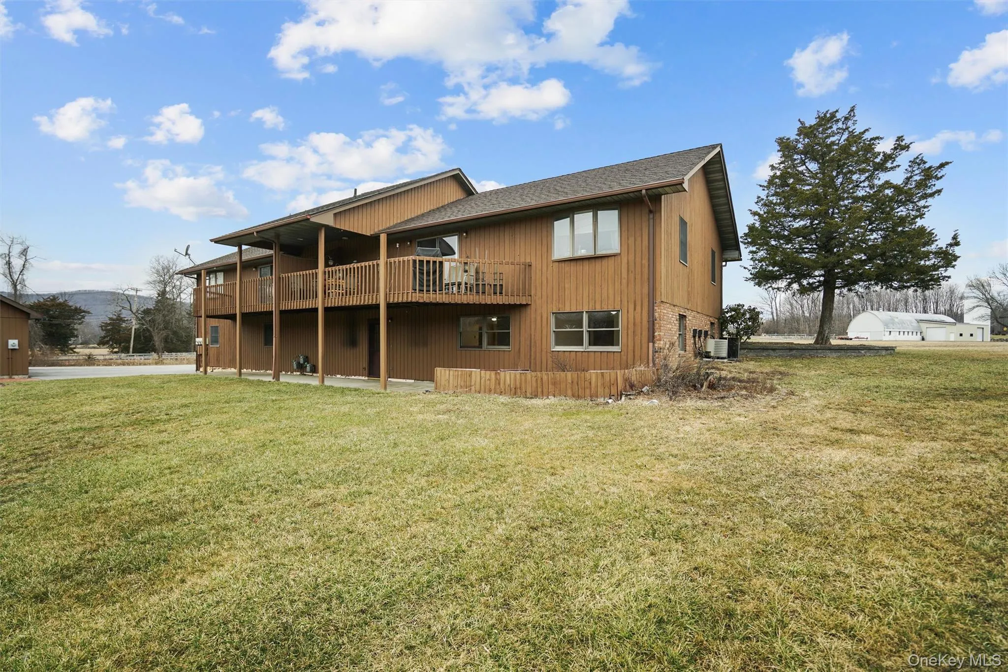 Back of house with a lawn and a deck with mountain view Back of house with a lawn and a deck with mountain view